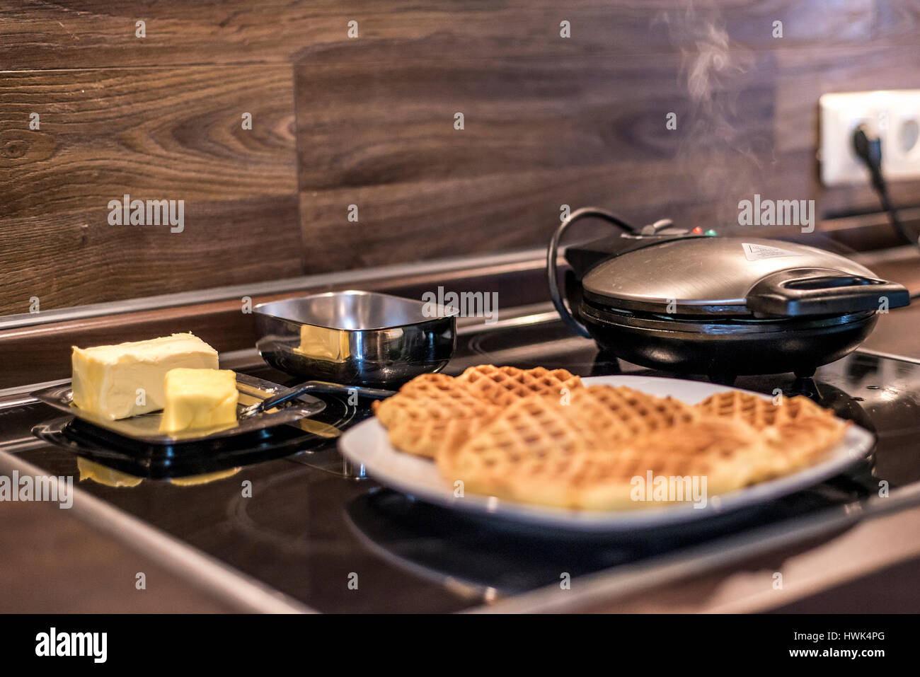 Hausgemachte Waffeln werden in einem Waffeleisen zubereitet. Stockfoto