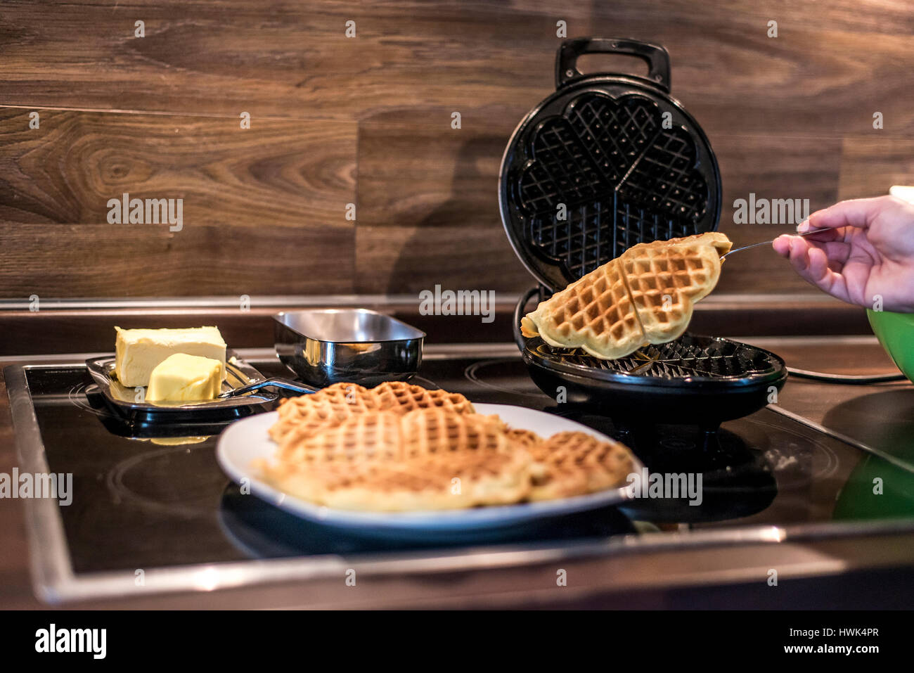 Hausgemachte Waffeln werden in einem Waffeleisen zubereitet. Stockfoto