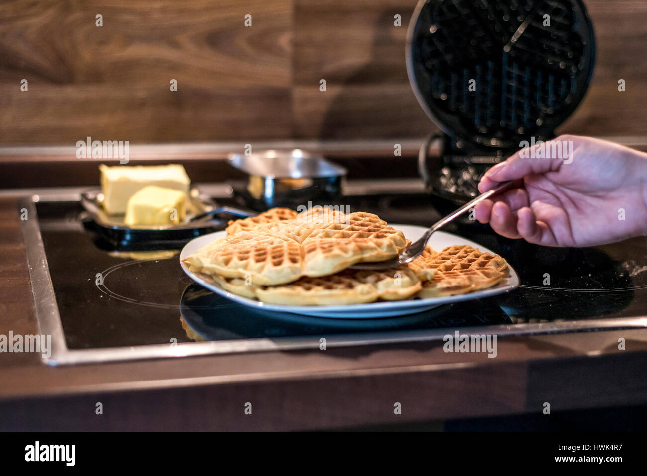 Hausgemachte Waffeln werden in einem Waffeleisen zubereitet. Stockfoto