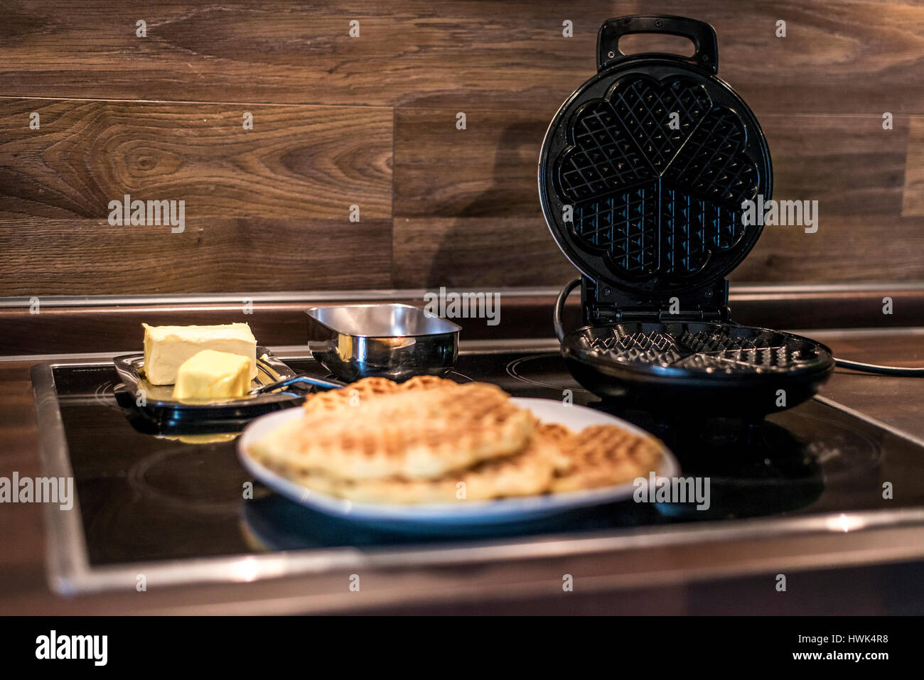 Hausgemachte Waffeln werden in einem Waffeleisen zubereitet. Stockfoto