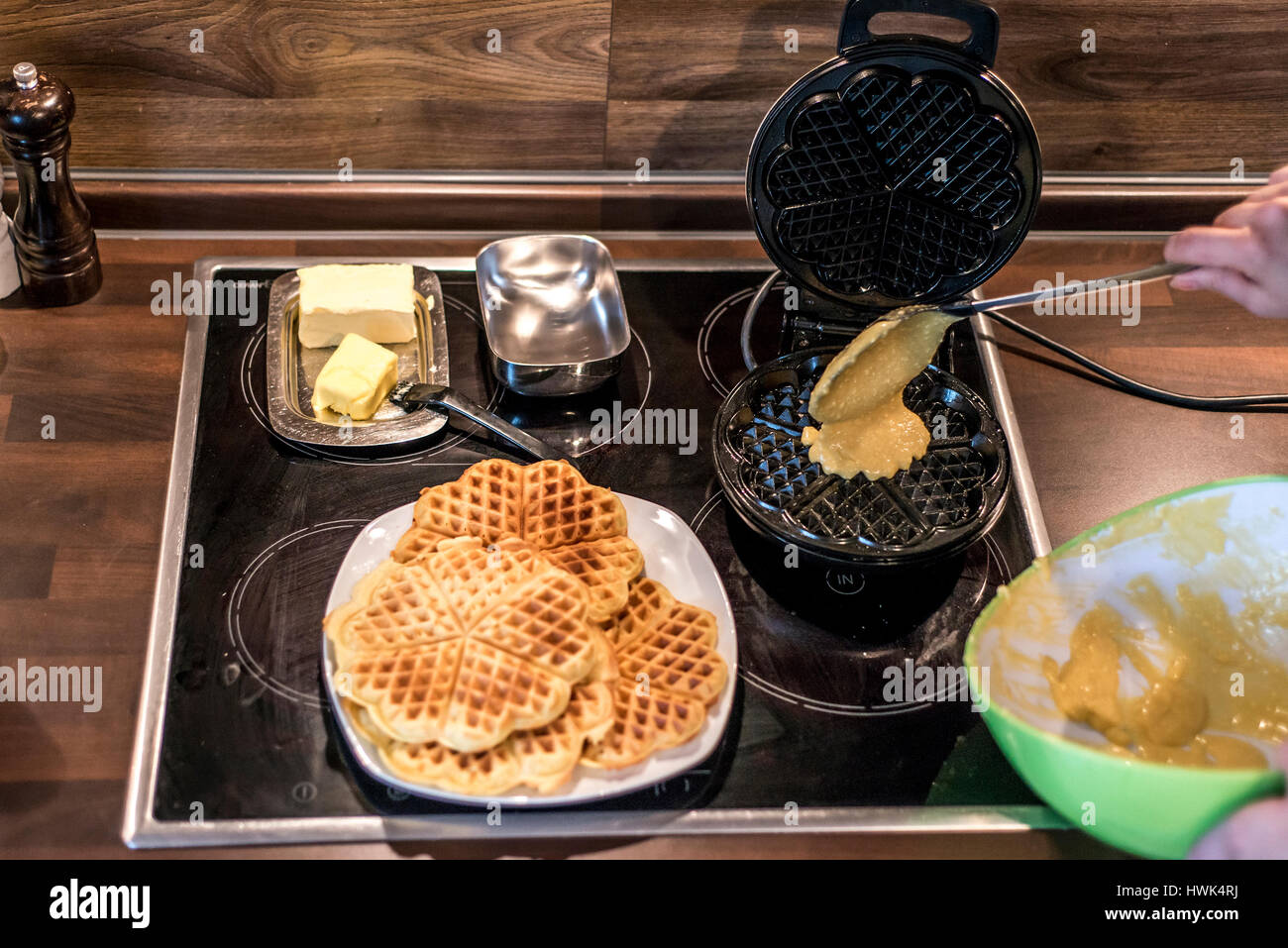 Hausgemachte Waffeln werden in einem Waffeleisen zubereitet. Stockfoto