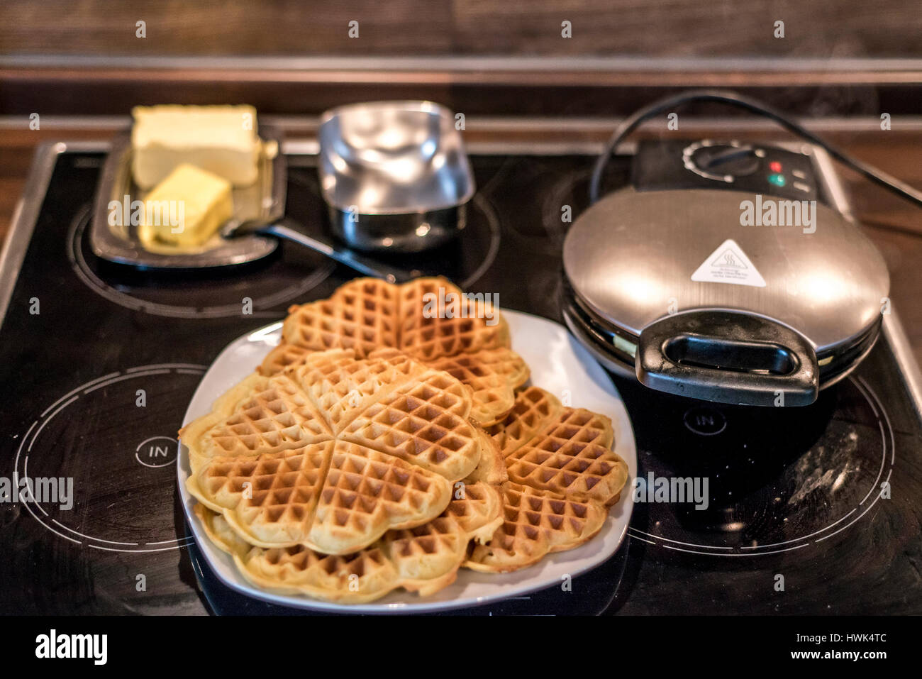 Hausgemachte Waffeln werden in einem Waffeleisen zubereitet. Stockfoto