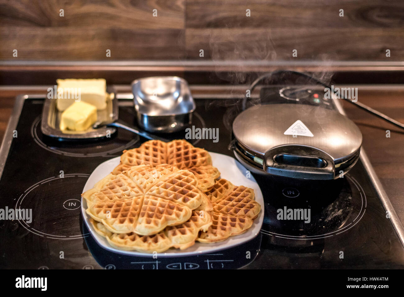 Hausgemachte Waffeln werden in einem Waffeleisen zubereitet. Stockfoto