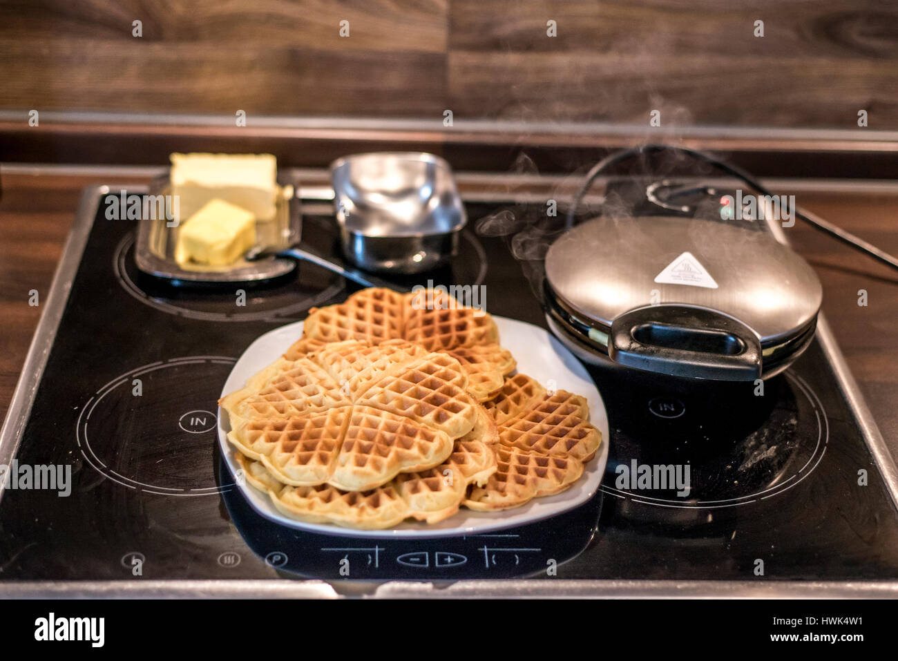 Hausgemachte Waffeln werden in einem Waffeleisen zubereitet. Stockfoto