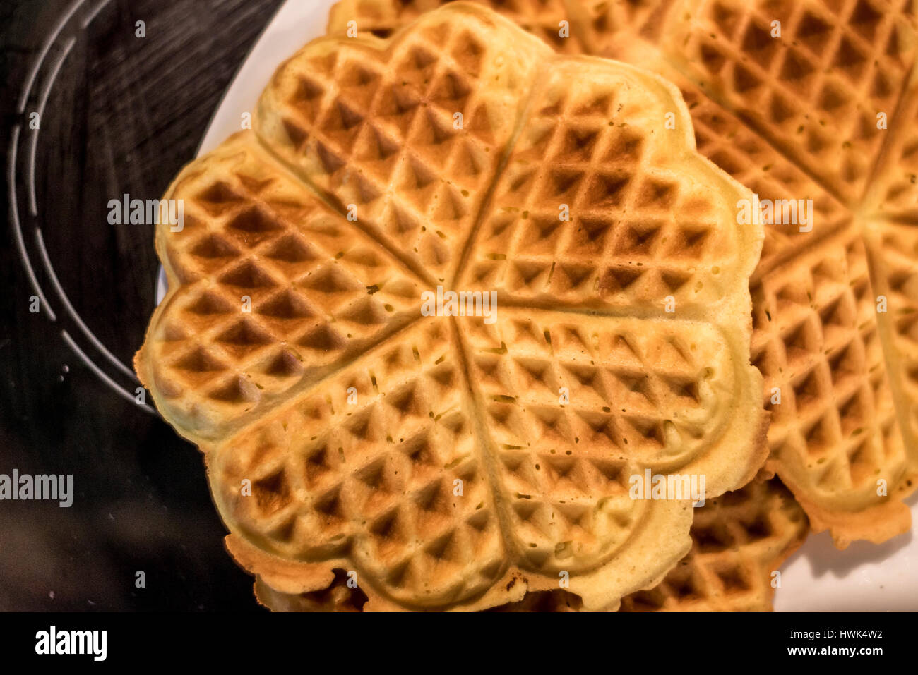 Hausgemachte Waffeln werden in einem Waffeleisen zubereitet. Stockfoto