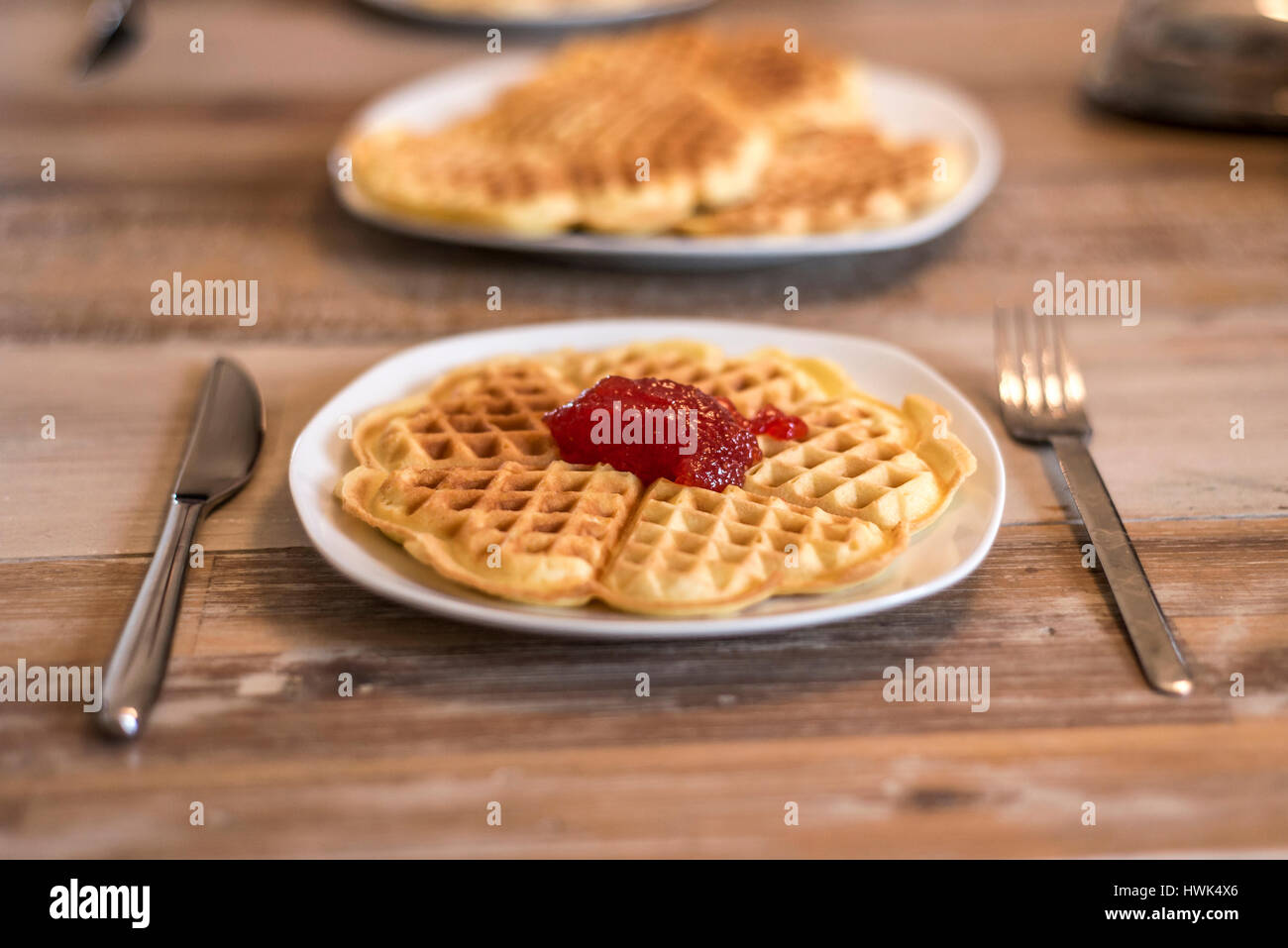 Essen hausgemachte Waffeln auf einem weißen Teller mit roten Erdbeer-Marmelade-Gelee Stockfoto