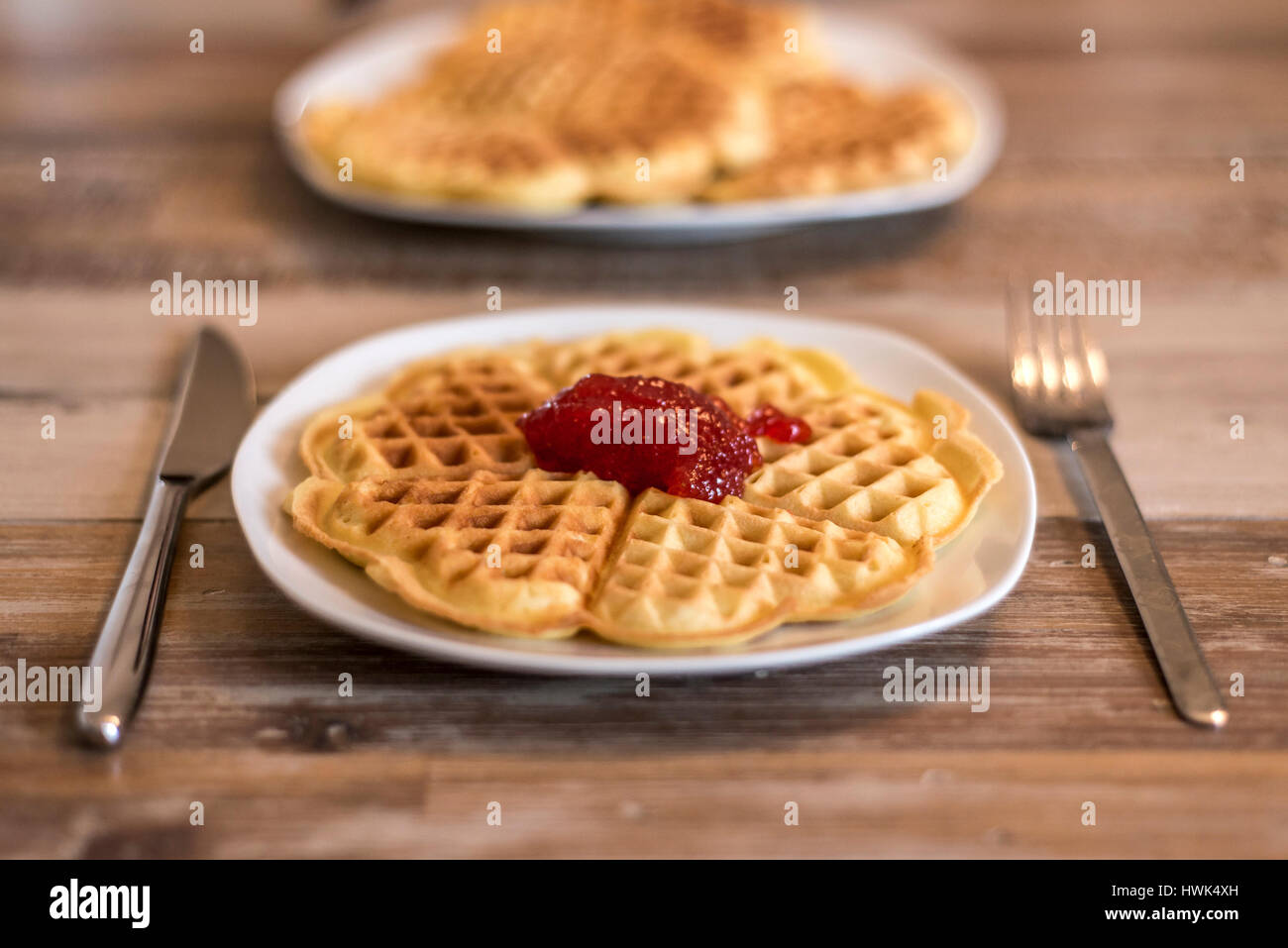 Essen hausgemachte Waffeln auf einem weißen Teller mit roten Erdbeer-Marmelade-Gelee Stockfoto
