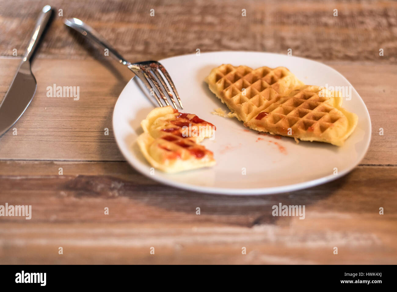 Essen hausgemachte Waffeln auf einem weißen Teller mit roten Erdbeer-Marmelade-Gelee Stockfoto
