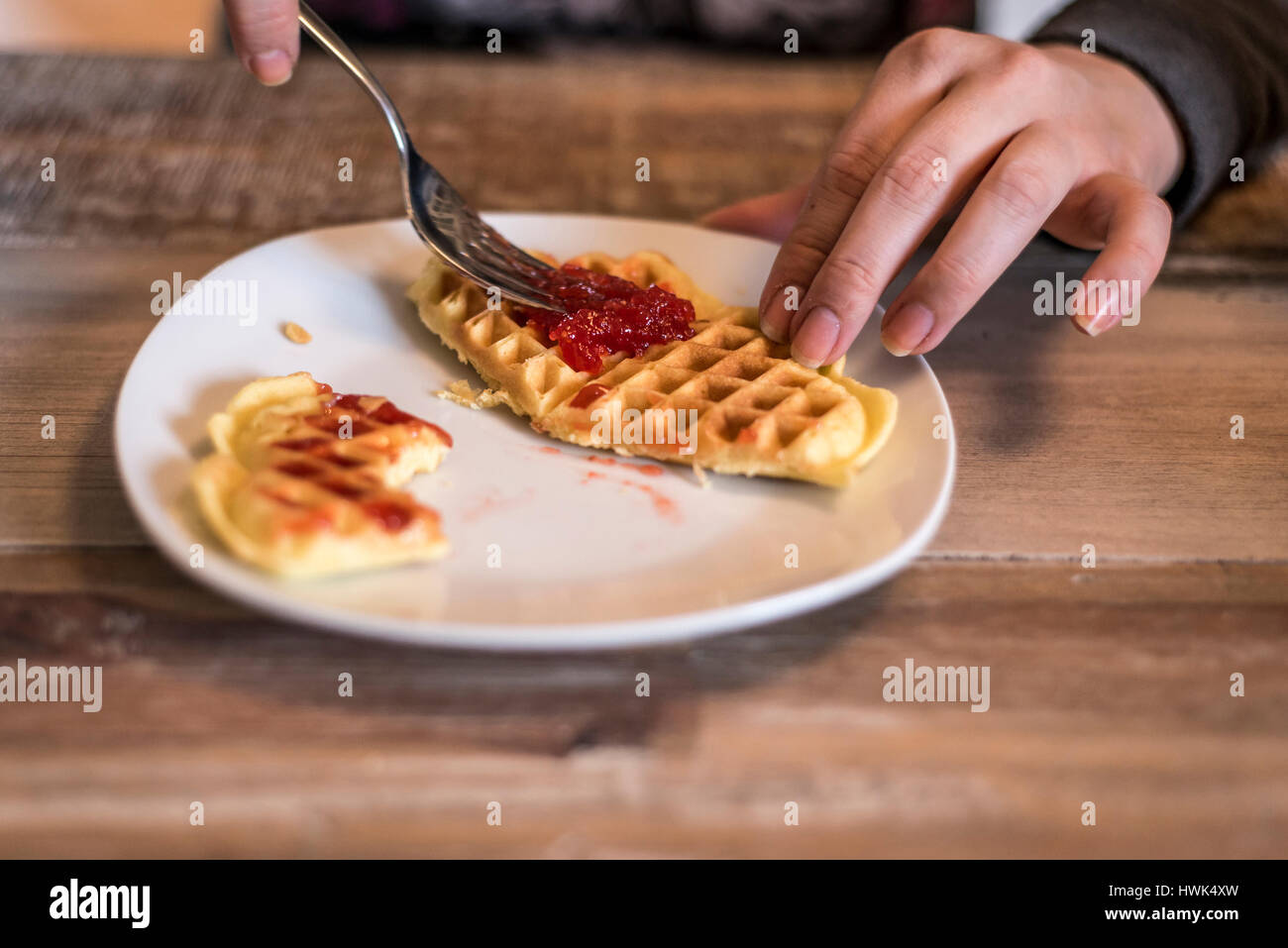 Essen hausgemachte Waffeln auf einem weißen Teller mit roten Erdbeer-Marmelade-Gelee Stockfoto