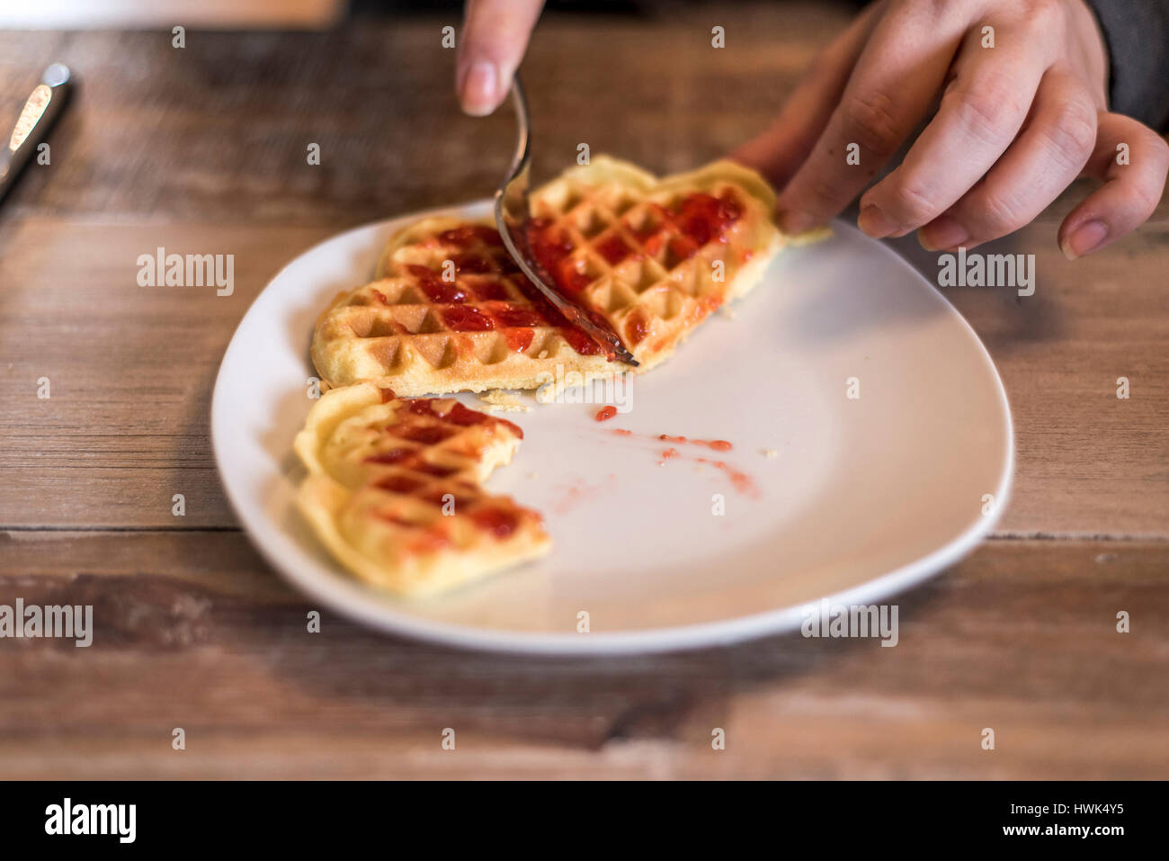 Essen hausgemachte Waffeln auf einem weißen Teller mit roten Erdbeer-Marmelade-Gelee Stockfoto