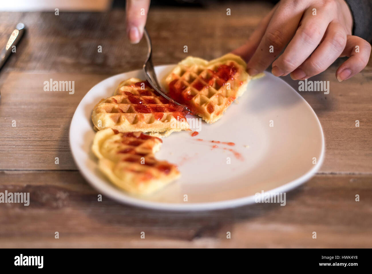 Essen hausgemachte Waffeln auf einem weißen Teller mit roten Erdbeer-Marmelade-Gelee Stockfoto