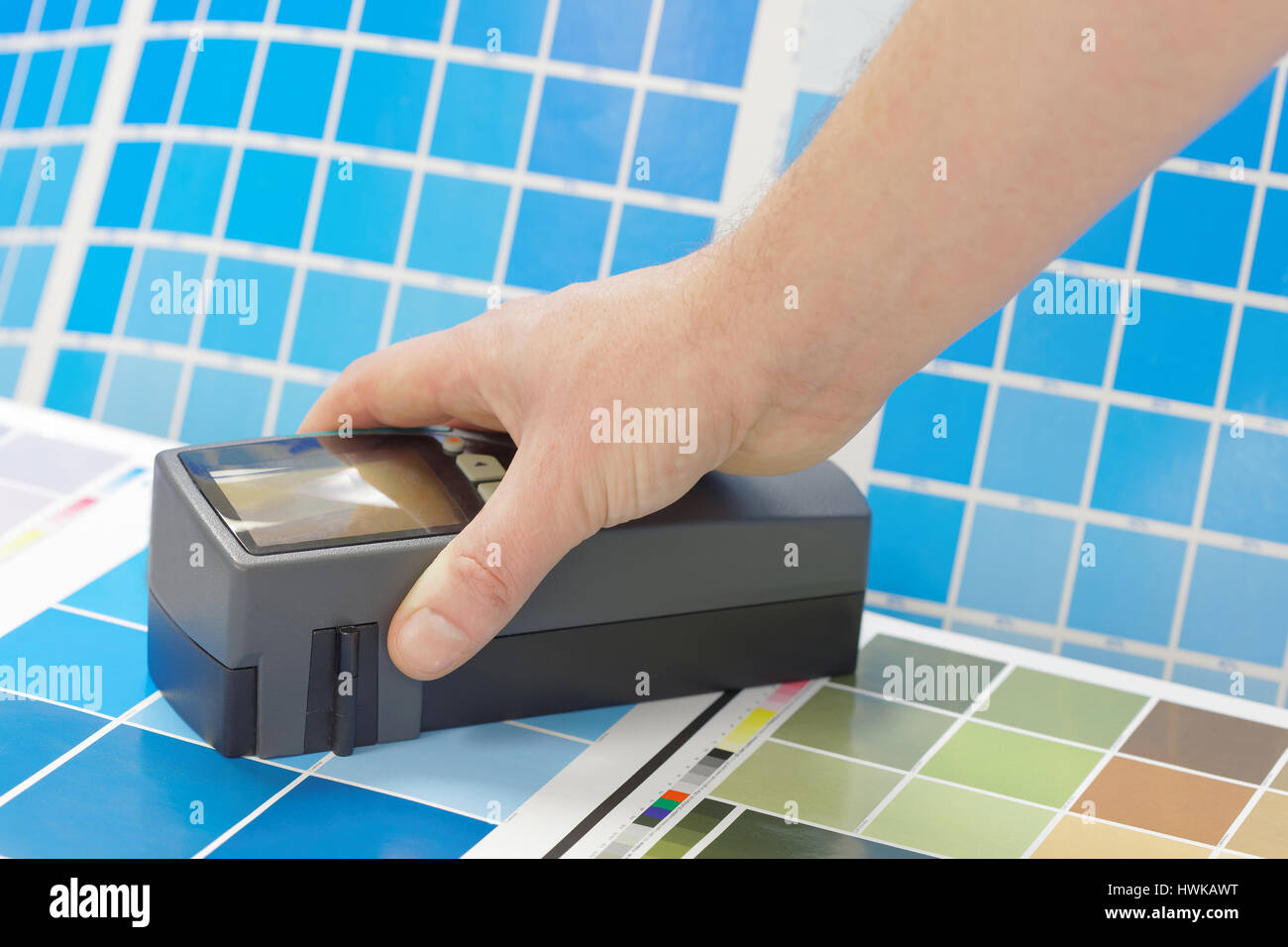 Scan-Densitometer und eine Hand auf einem Blatt einen blaugrünen Testdruck in einem pre-Press-workshop Stockfoto