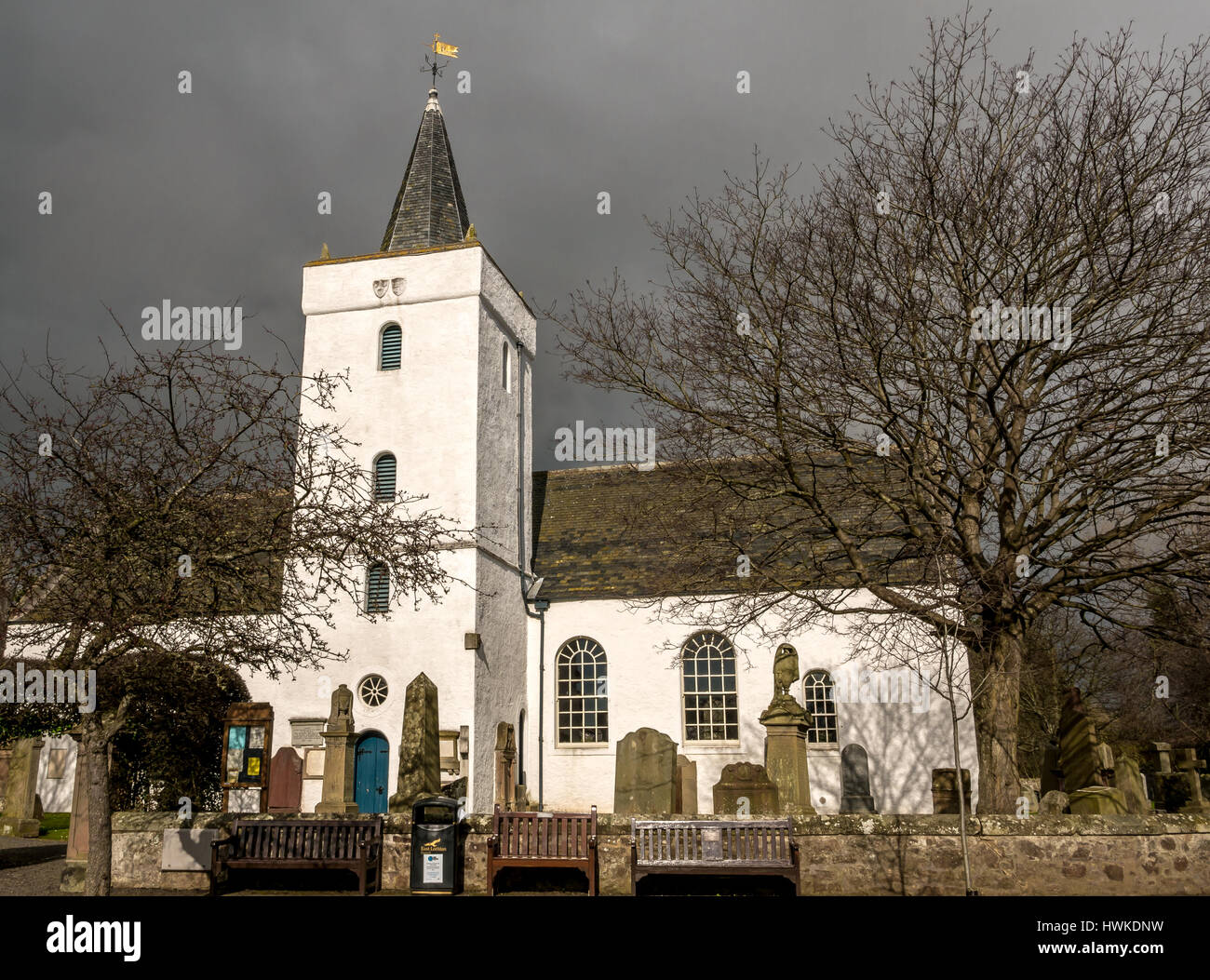 Weiß getünchte alte Yester Parish Church in Gifford, East Lothian, Schottland, Großbritannien mit launisch dunklen stürmischen Himmel Stockfoto
