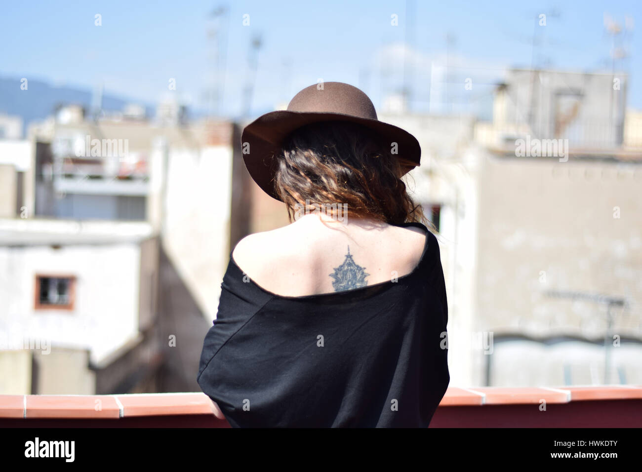 Einsame junge Frau in braunen Hut aus der zurück denken auf Terraсe, Barcelona, gotische Viertel Stockfoto
