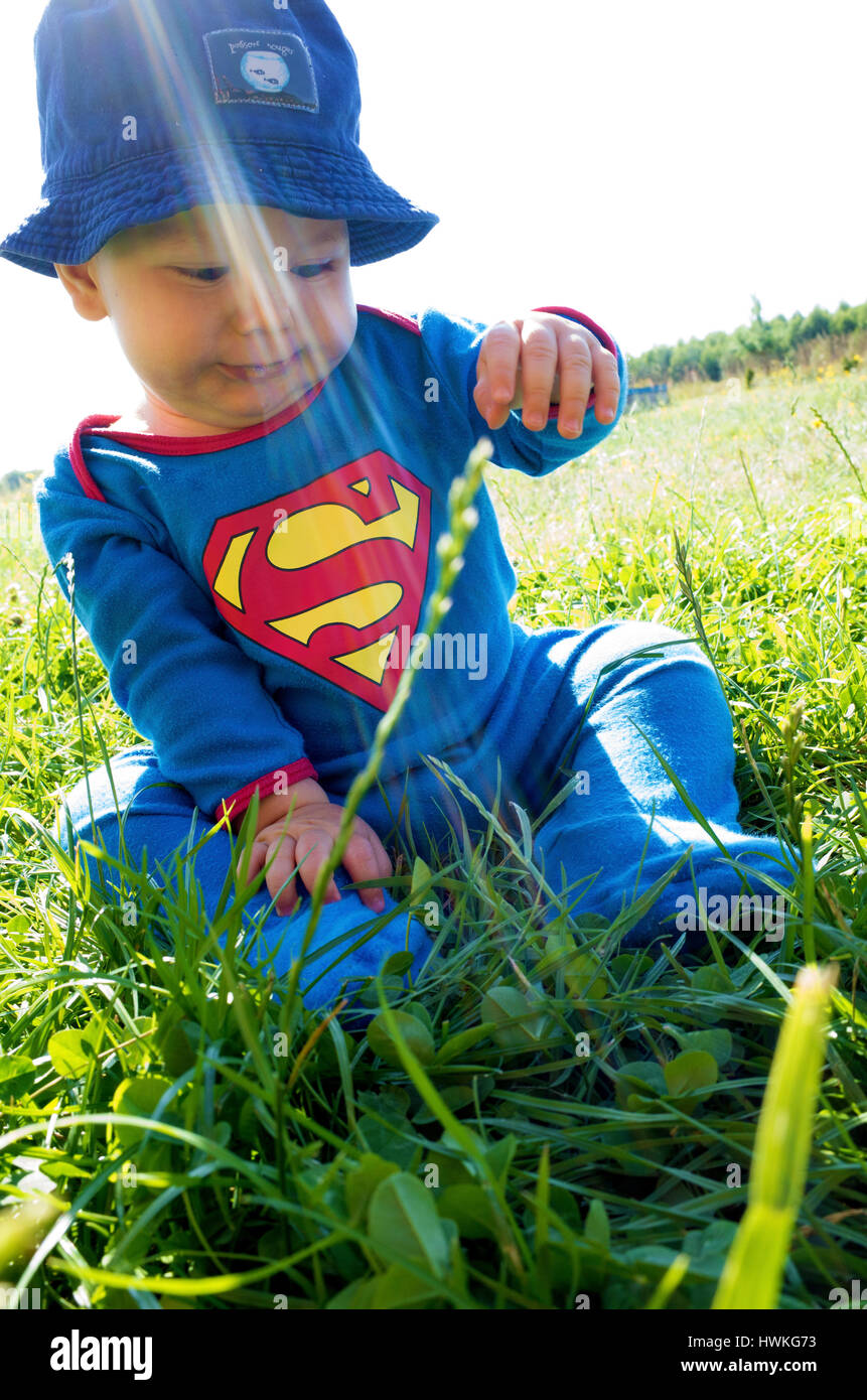 Wenig Superman Polnisch baby junge im Alter von 7 Monaten mit dem Rasen spielen. Zawady Zentralpolen Europa Stockfoto