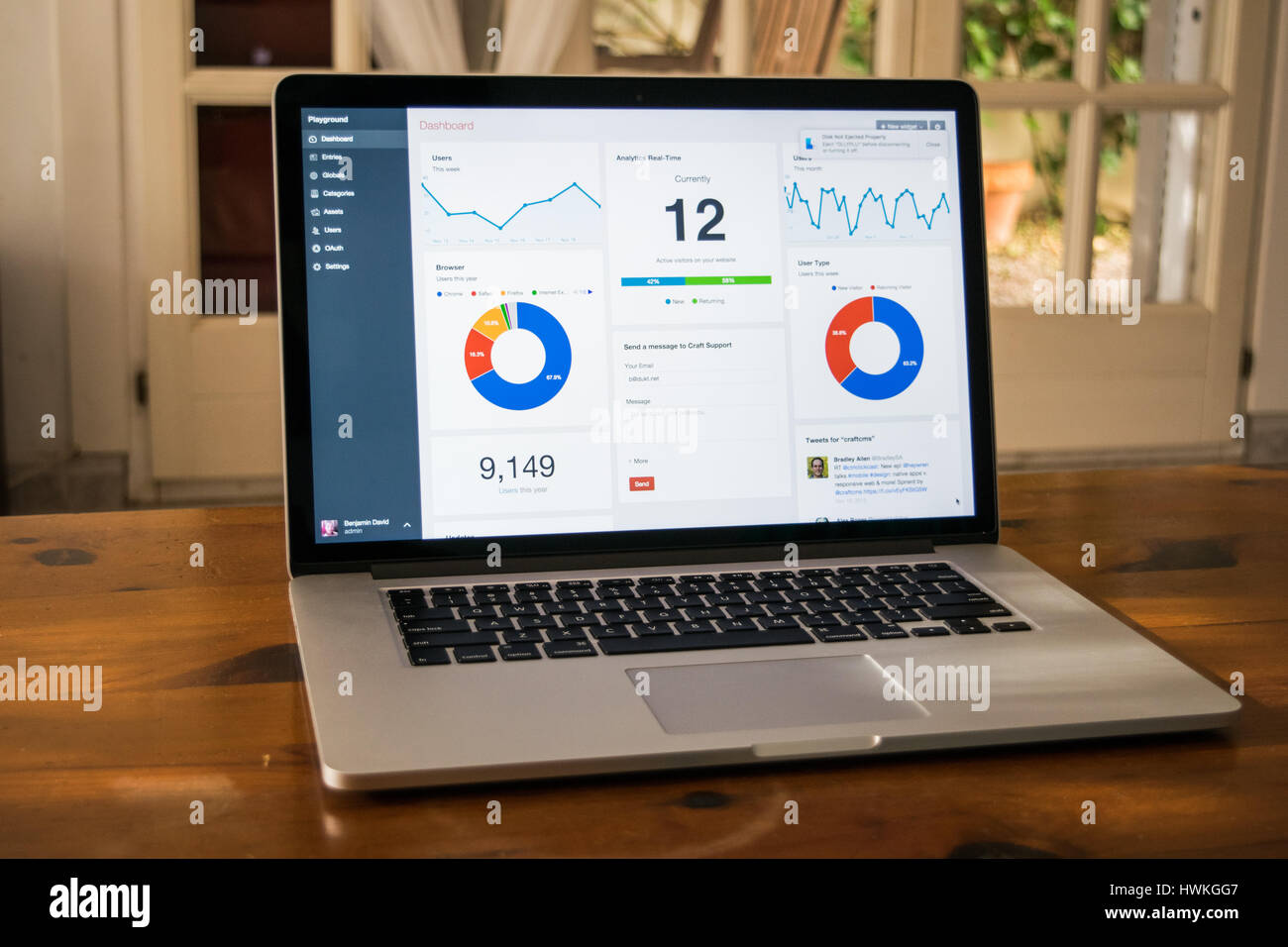 Silber Laptop mit analytischen Grafik auf dem Bildschirm auf den Holztisch in Wohngebäude Stockfoto