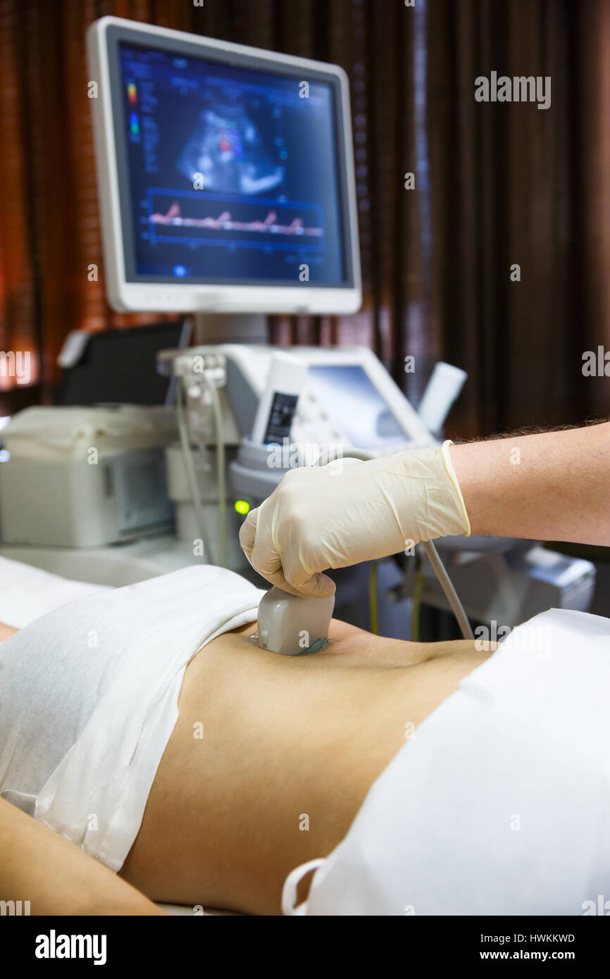 Arzt in einem Krankenzimmer Diagnose eine Ultraschalluntersuchung der Patienten Bauch mit konvex-Sonde zu tun. Moderne Medizintechnik, vorbeugende Medizin und h Stockfoto