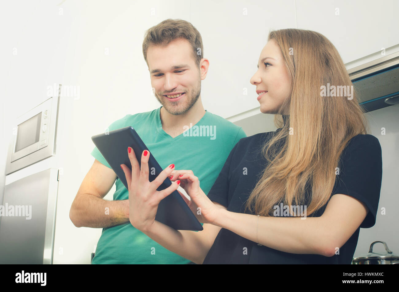 Junge Menschen, die kochen in der Küche überprüfen Top Rezepte auf Tablet. Küche-paar zu Hause Koch männlich weiblich Tablet-Konzept Stockfoto