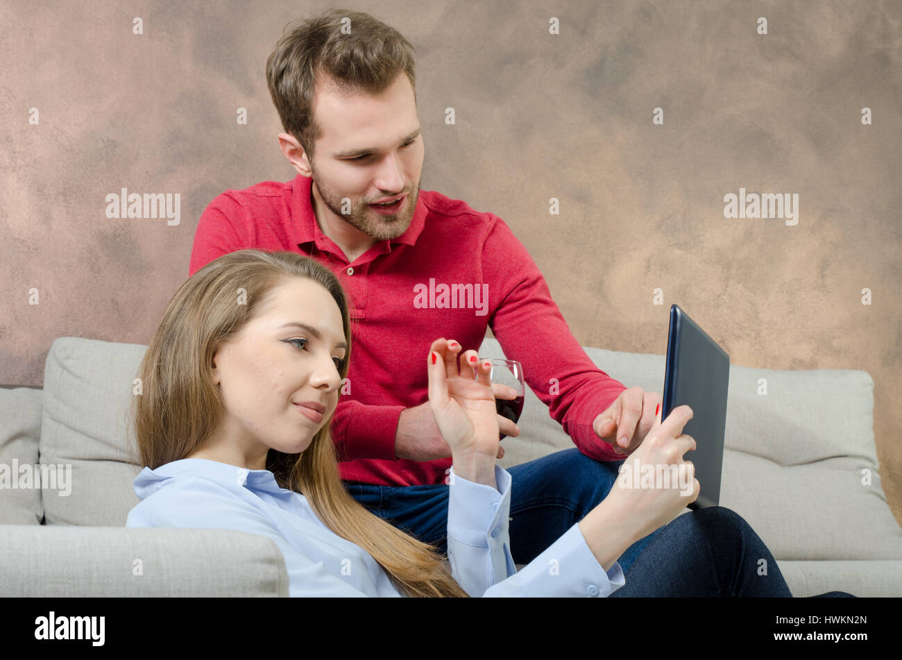 Paar verbringt Freizeit. Frau mit einem Tablett in Händen. Frau Tablet halten hinter Lifestyle Freizeit indoor paar-Konzept Stockfoto