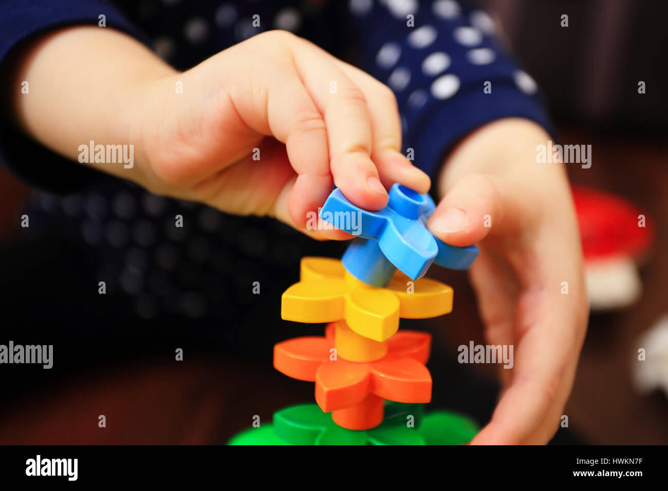 Kinderhand mit bunten Konstruktor Details Closeup. Kinder spielen Hintergrund. Stockfoto
