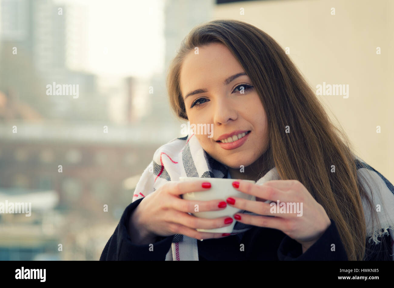 Frau, trinken Kaffee oder Tee mit Tasse auf dem Balkon. Stockfoto