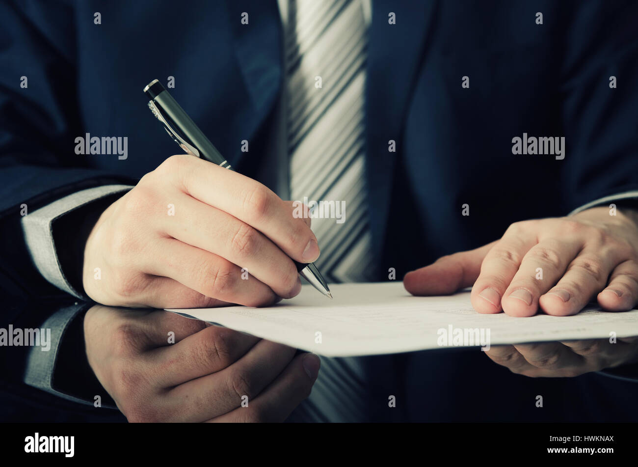 Geschäftsmann unterschreibt einen Vertrag. Mann Vertragsunterzeichnung Handschrift Stift schreiben Papier Konzept Stockfoto