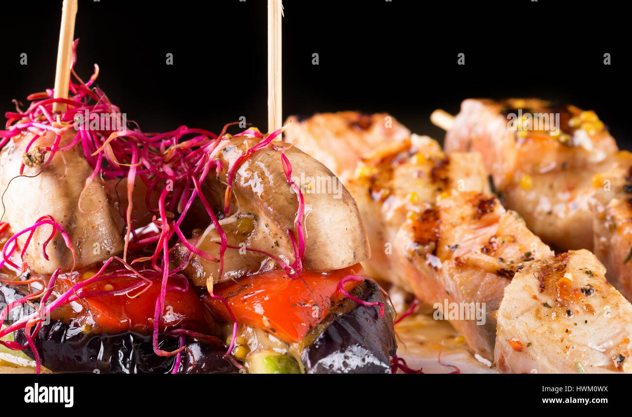 Gegrilltes Hühnerfleisch auf Stick auf einem schwarzen Hintergrund. Stockfoto