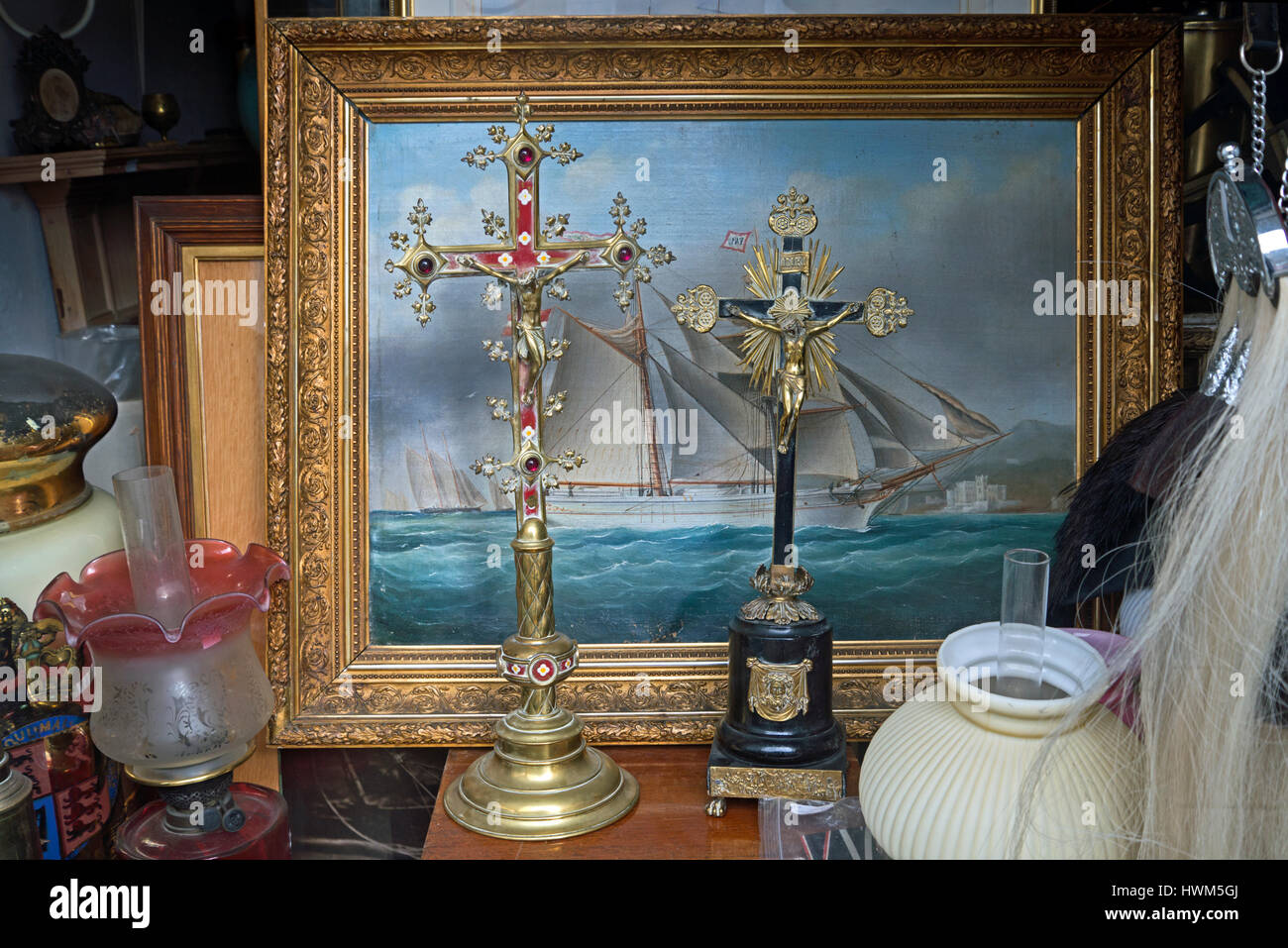 Gemälde von einem Segelschiff und Kruzifixe im Fenster ein Antiquitätengeschäft in Edinburghs Neustadt. Stockfoto