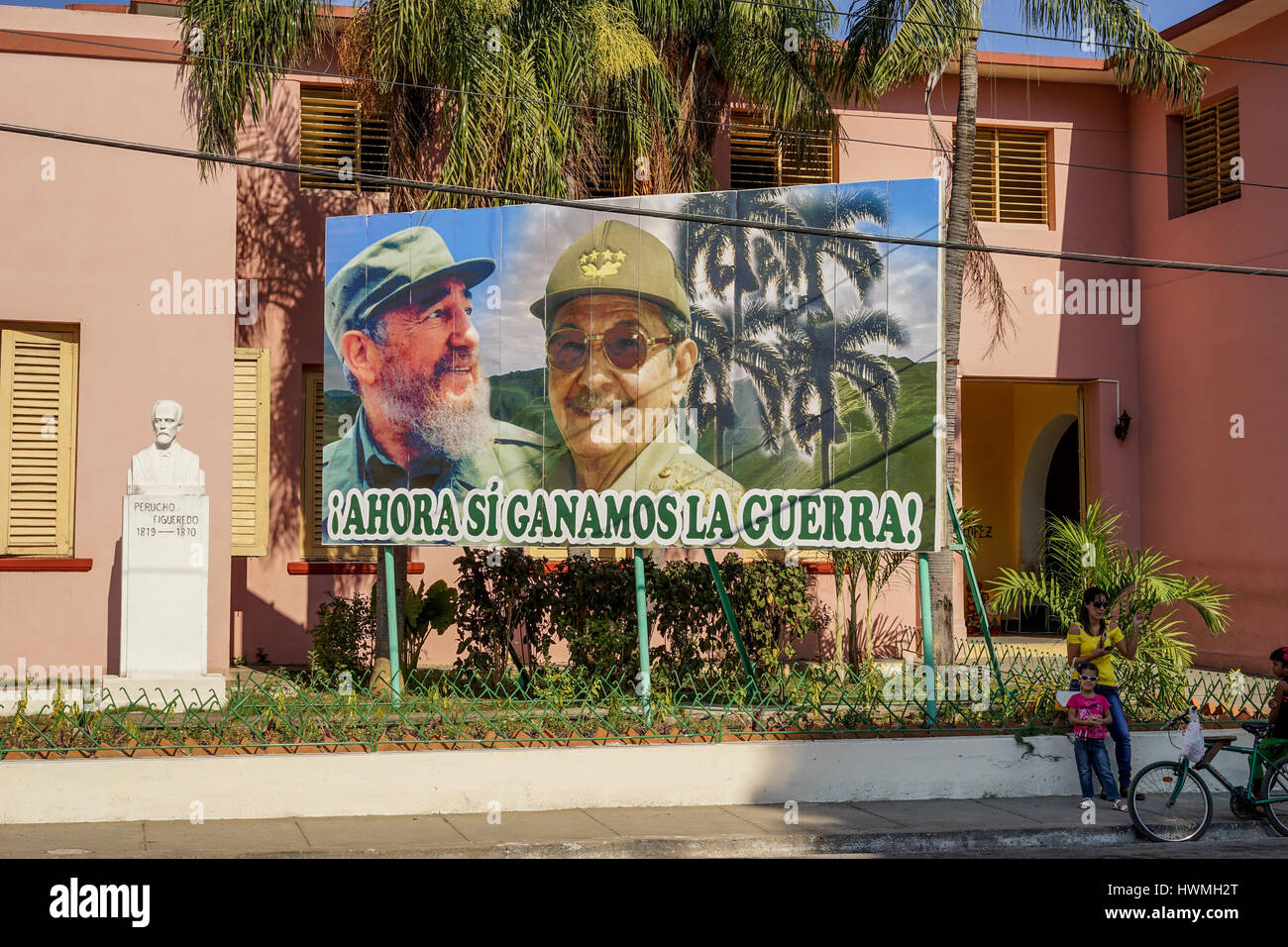 Santiago De Cuba, Kuba - 12. Januar 2016: typische Szene einer der Straßen im Zentrum von Santiago De Cuba - großes Plakat von Raul und Fidel Castro. PE Stockfoto