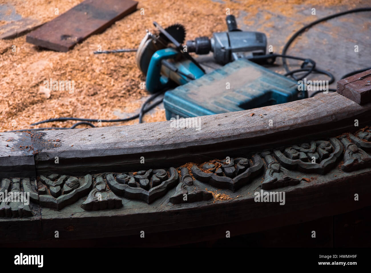 Werkzeuge für die Holzbearbeitung und Hackschnitzel hinter geschnitzten Holzplastik im Sanctuary of Truth in Pattaya, Thailand Stockfoto