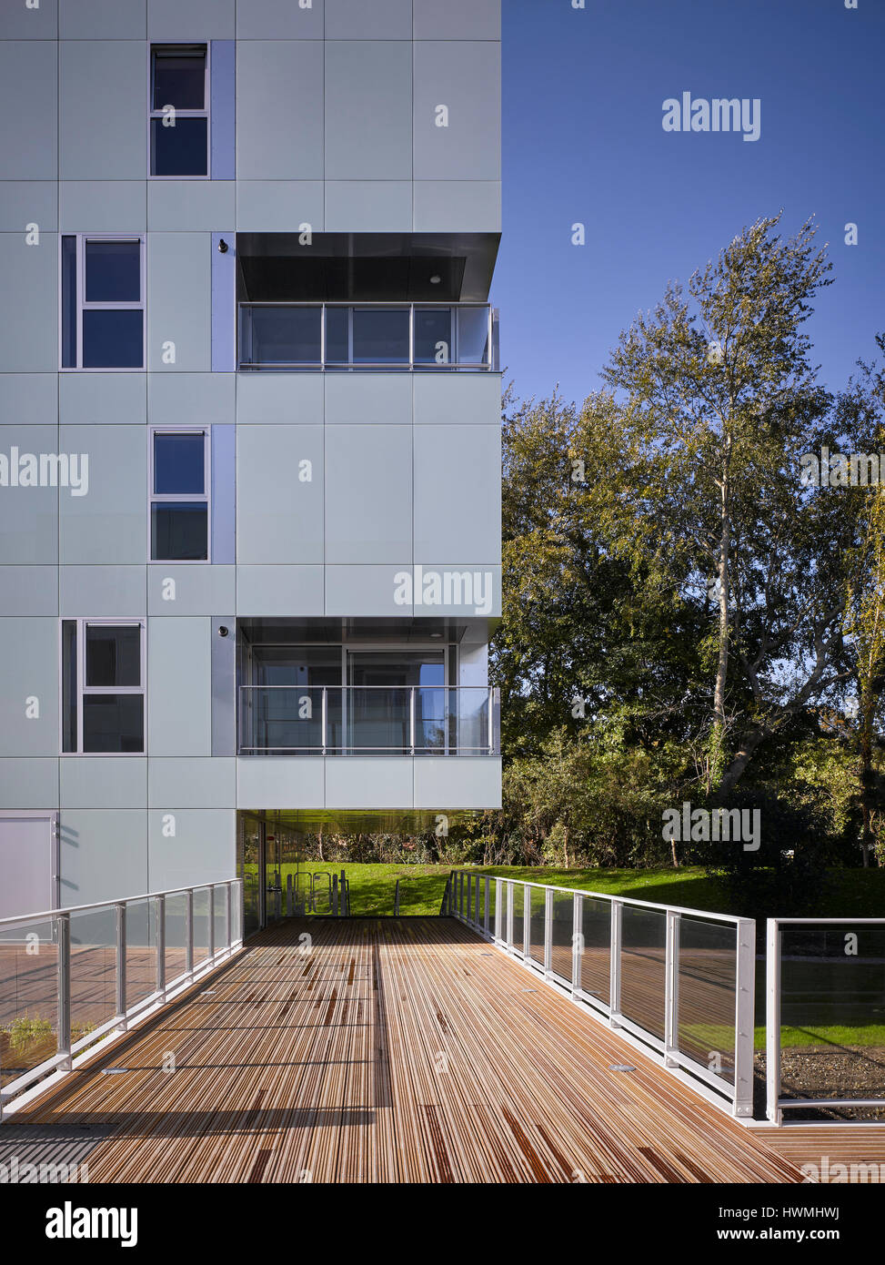 Außenfassade, reflektierende Glasverkleidung und Gehweg über Fluss zeigt. Dunluce Apartments, Ballsbridge, Irland. Architekt: Derek Tynan Architekten, Stockfoto