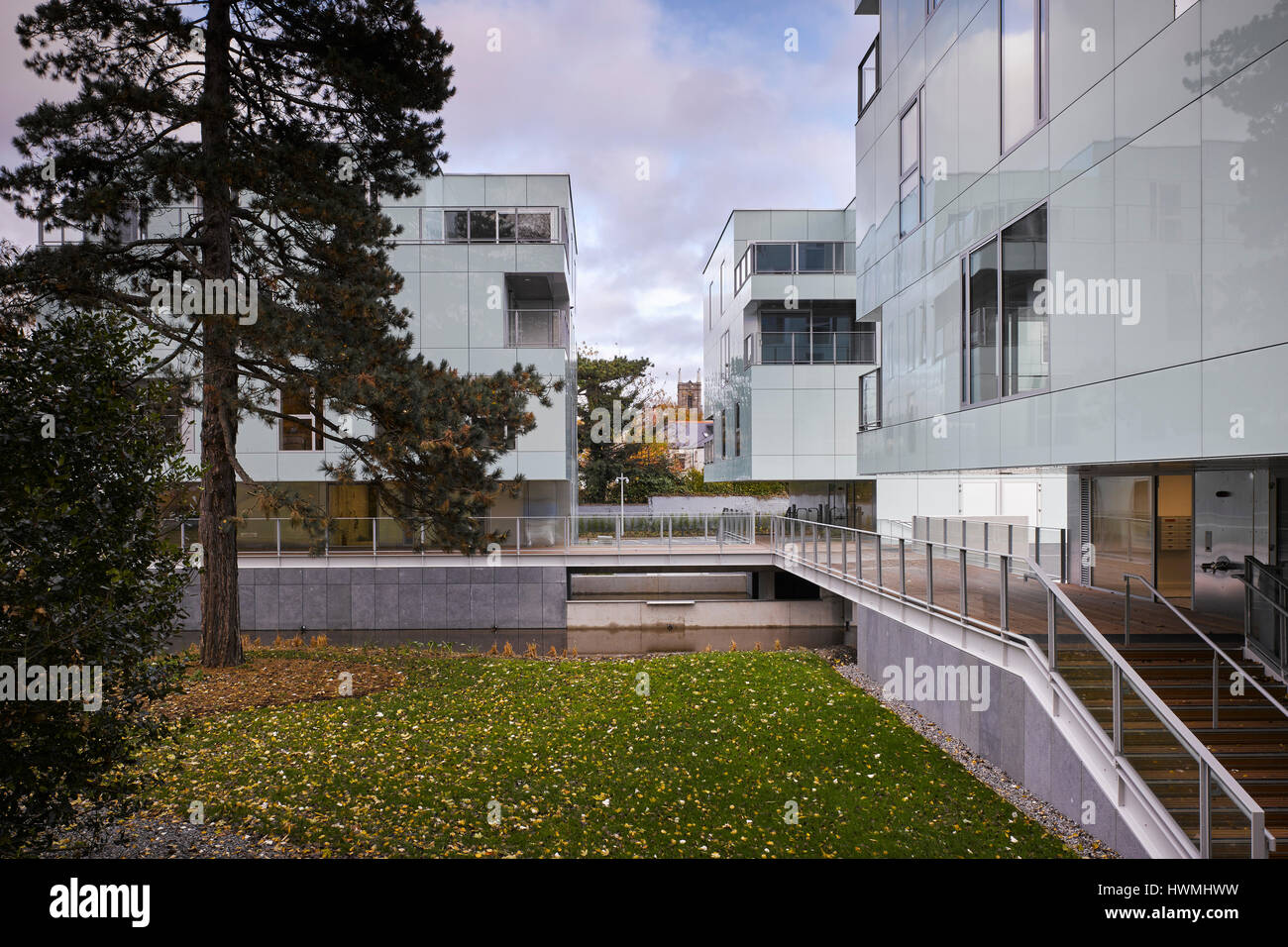 Die Außenansicht zeigt Gehweg über Fluss und Gelände. Dunluce Apartments, Ballsbridge, Irland. Architekt: Derek Tynan Architekten, 2016. Stockfoto