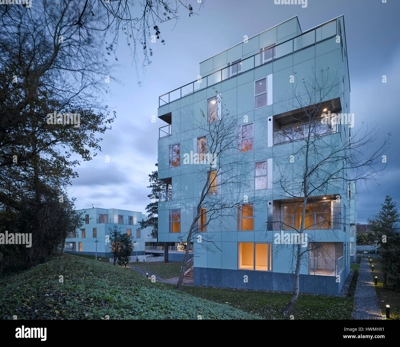 Abenddämmerung Blick von außen zeigt Gehweg und Innenraum beleuchtet. Dunluce Apartments, Ballsbridge, Irland. Architekt: Derek Tynan Architekten, 2016. Stockfoto
