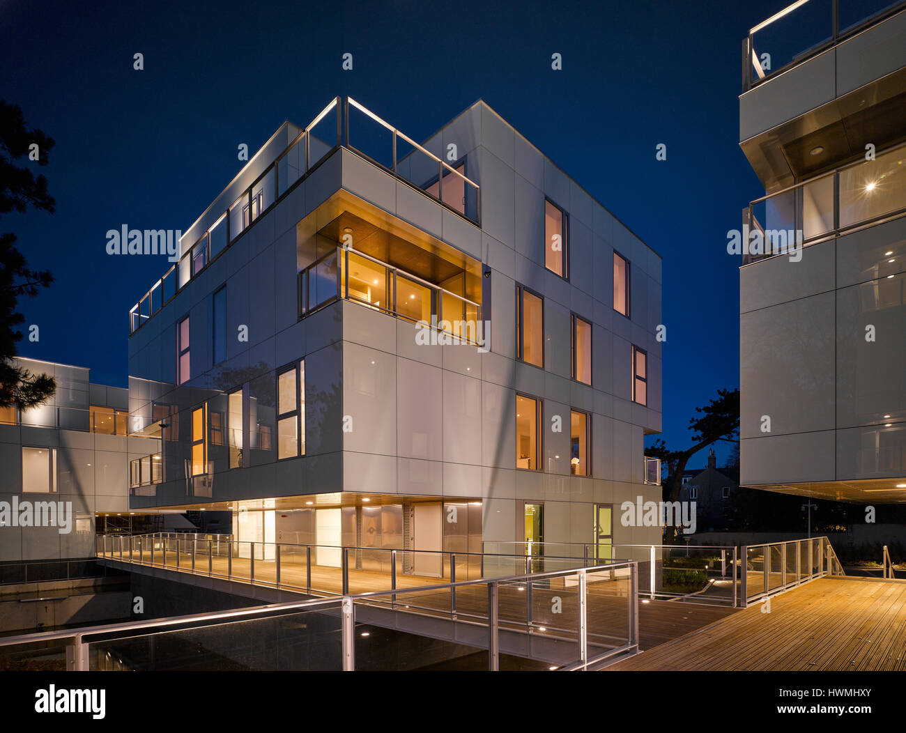Nachtansicht von außen zeigen beleuchtete Innenräume und Gehweg. Dunluce Apartments, Ballsbridge, Irland. Architekt: Derek Tynan Architekten, 2016. Stockfoto