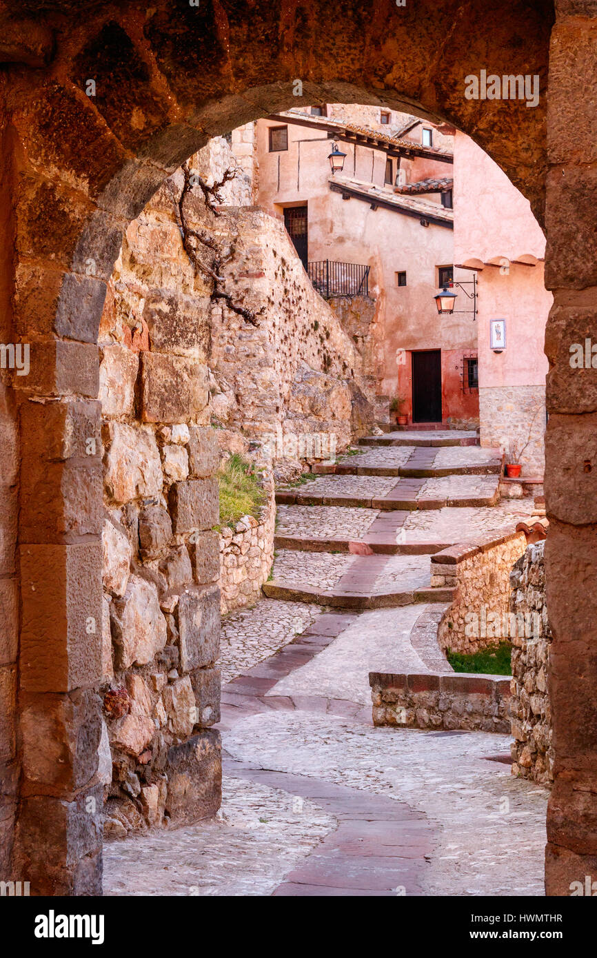 Mittelalterliche Straße mit Treppen, die durch eine Tür mit einem Rundbogen gesehen. ALBARRACIN, Spanien. Stockfoto