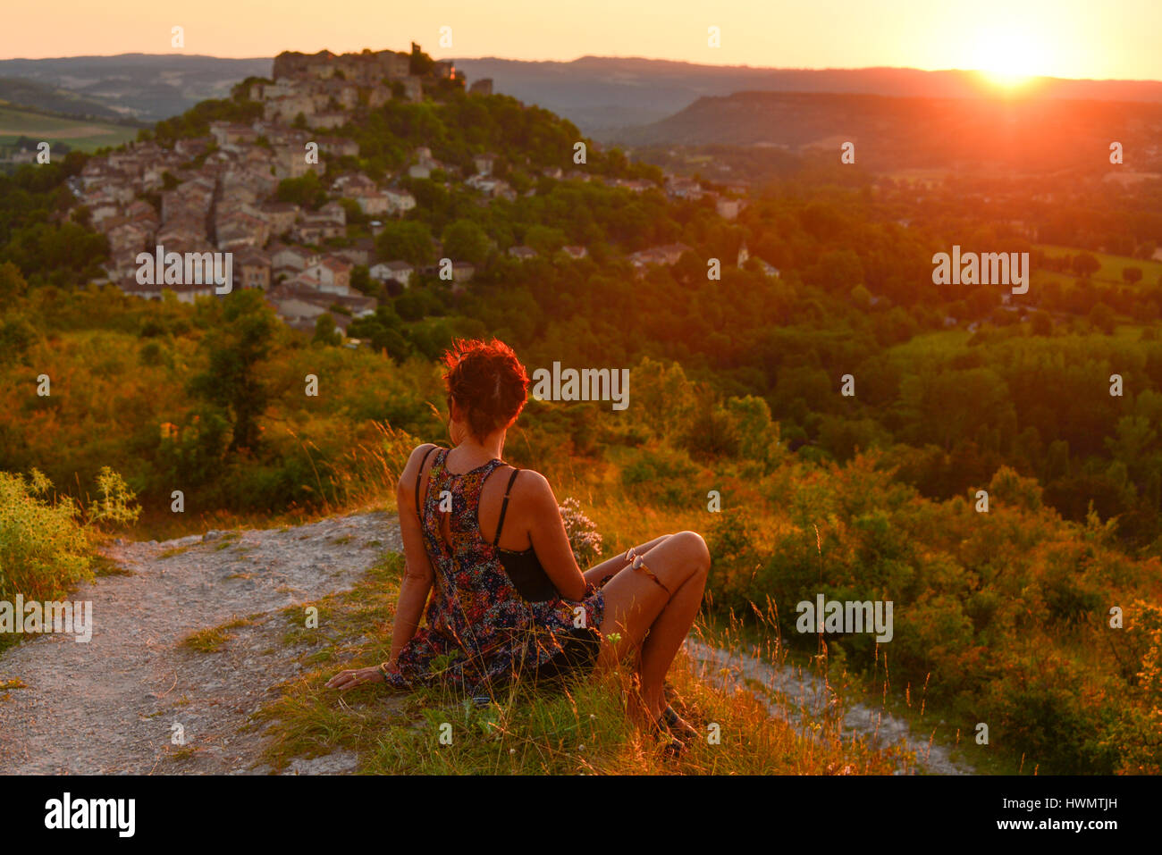 Frau den Sonnenuntergang von Grain de Sel, einem Hügel mit Blick auf das mittelalterliche Dorf von Cordes-Sur-Ciel, in Occitanie, Frankreich. Stockfoto