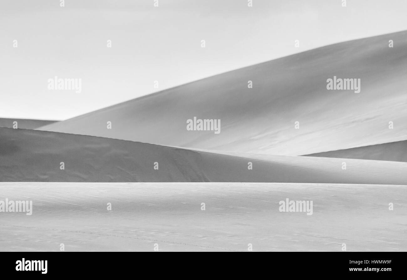 Wohnhaft Linien und Formen durch Sanddünen unter heißem Himmel in Schwarz-Weiß-Konvertierung gebildet. Stockfoto
