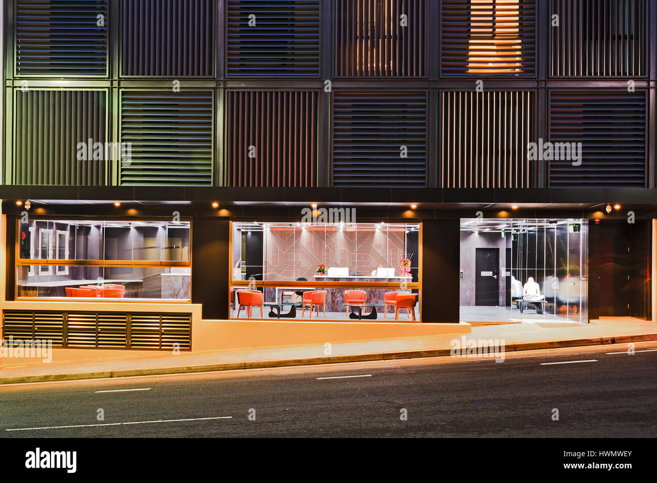 Sydney, Australien 18.02.2017 - modernes Hostel in Top Ryde Sydney bei Nacht mit heller Beleuchtung der Empfangsbereich durch Glasfenster und Türen Stockfoto