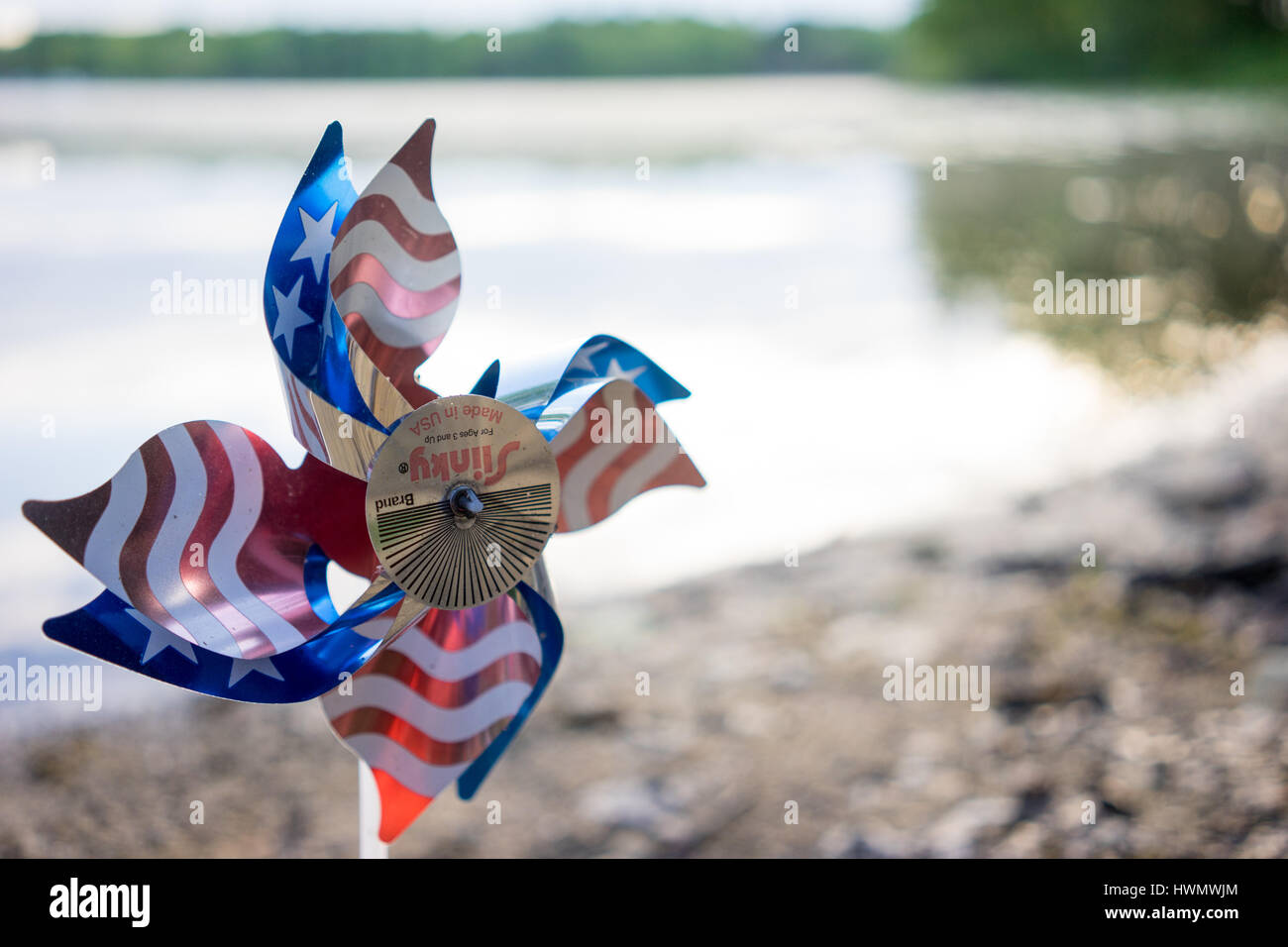 Eine amerikanische Flagge Pin Rad sitzt im Schlamm an der Seepromenade. Stockfoto