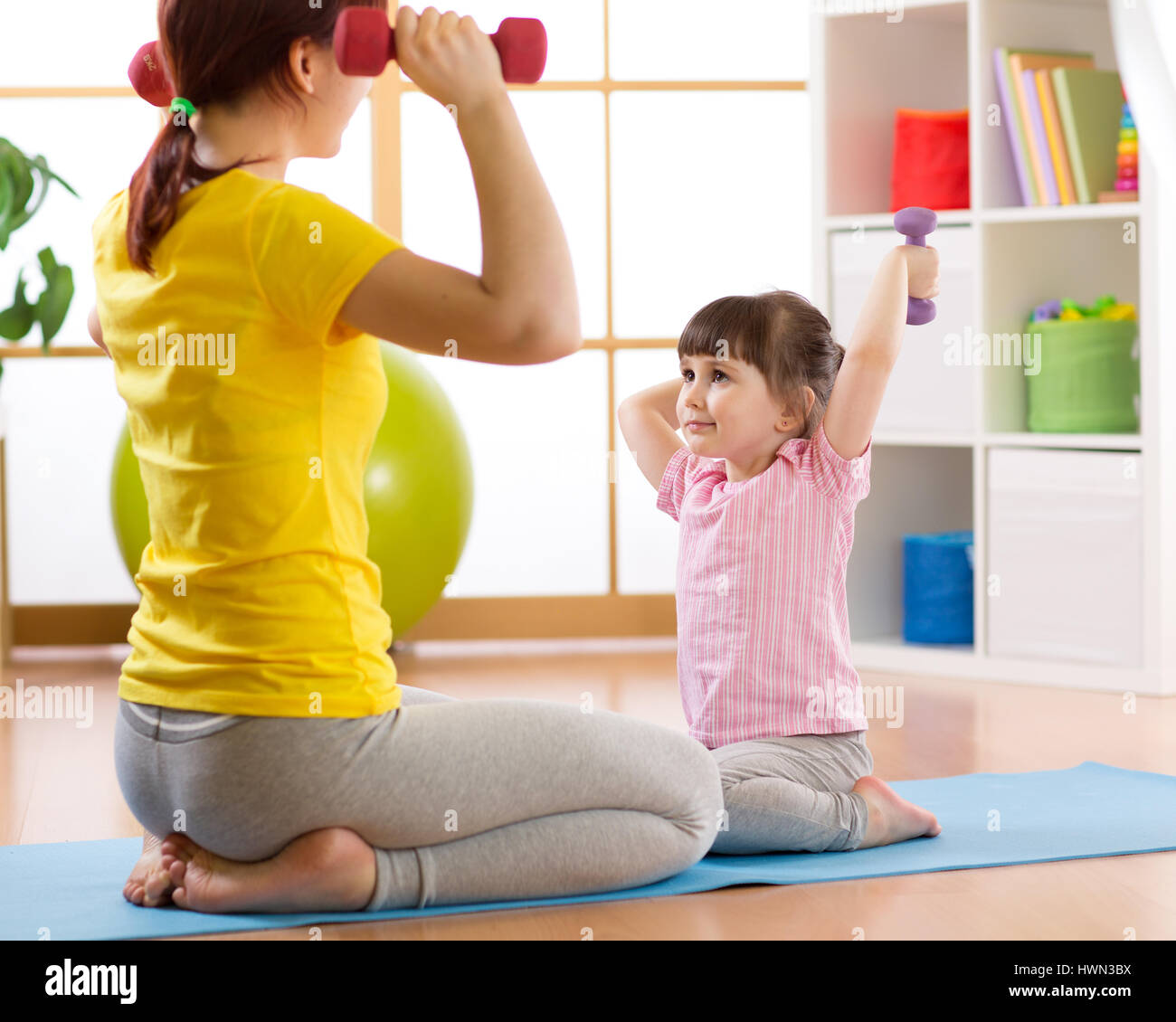 Mutter und Kind Tochter training mit Hanteln im Hause Zimmer Stockfoto