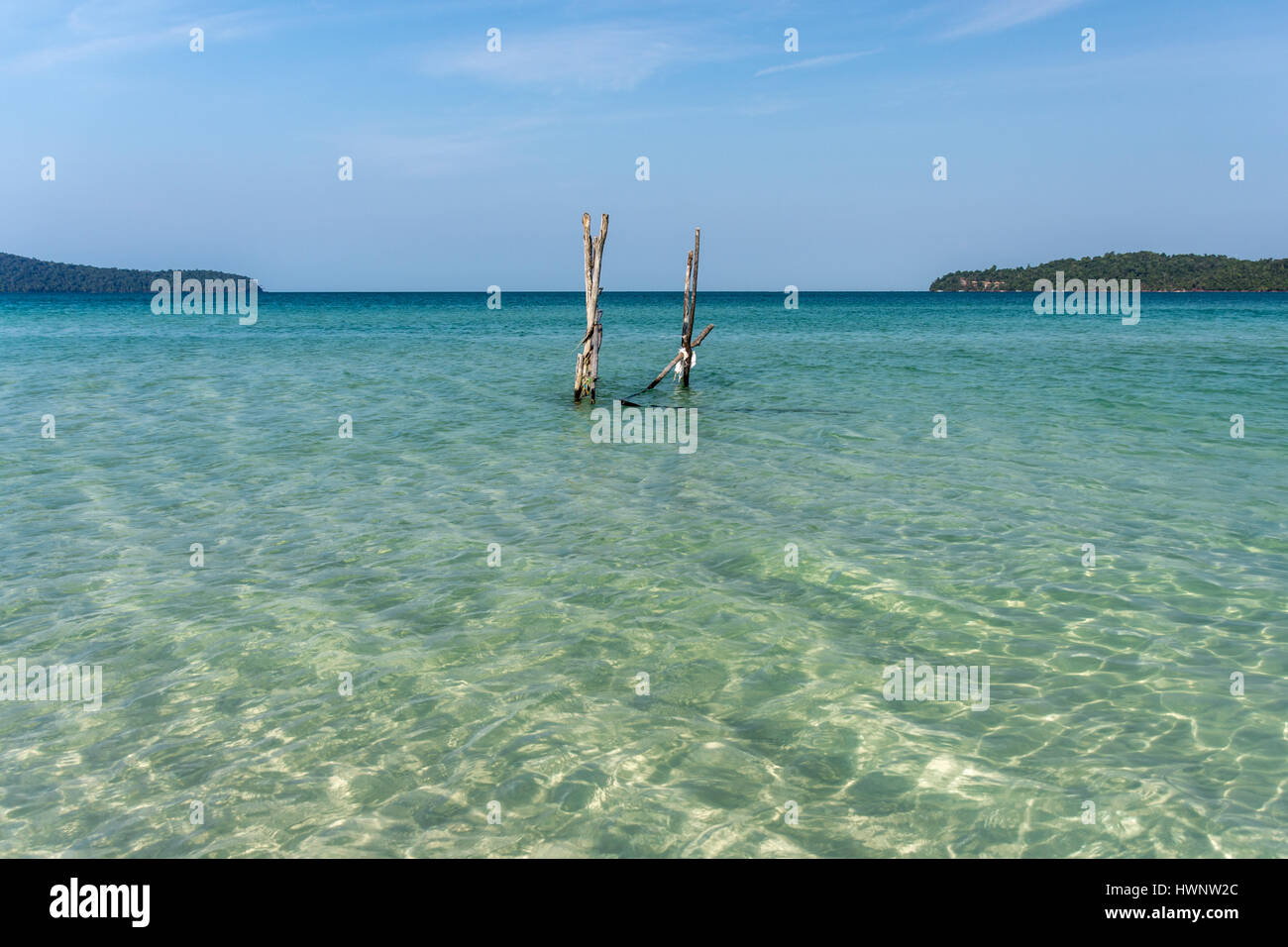 Ein Paradiesstrand einer tropischen Inseln Bucht mit Landzunge in der Ferne. Stockfoto