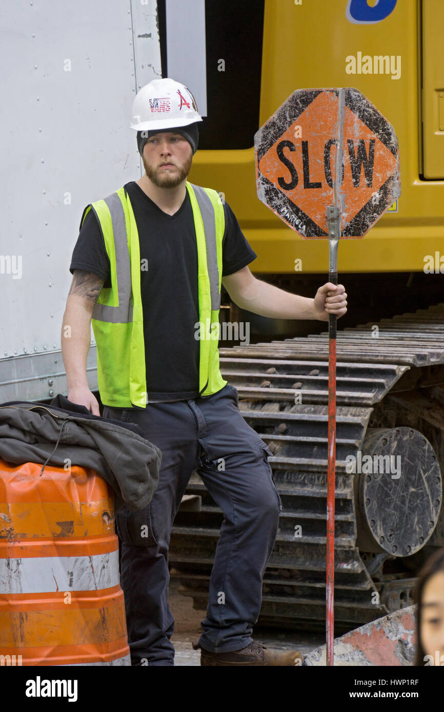 Ein Bauarbeiter, Regelung des Verkehrs auf der West 4th Street in Greenwich Village, Manhattan, New York City. Stockfoto