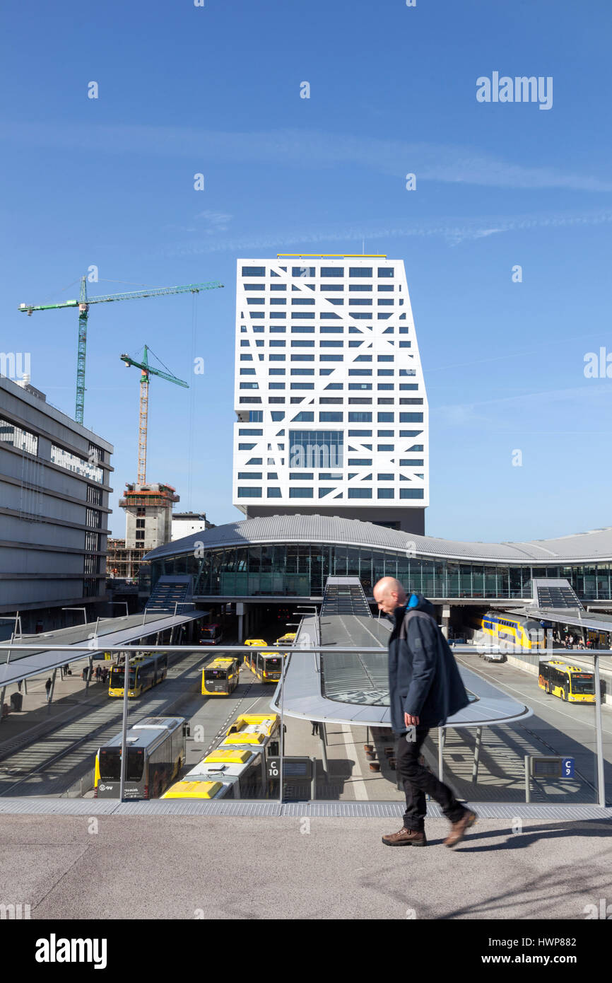 Utrecht, 15 2017: Mann geht über Eisenbahn hinter Bus Bahnhof Utrecht über Steg an sonnigen Frühlingstag Stockfoto Utrecht, 15 2017: Mann geht über Eisenbahn hinter Bus Bahnhof Utrecht über Steg an sonnigen Frühlingstag Stockfoto