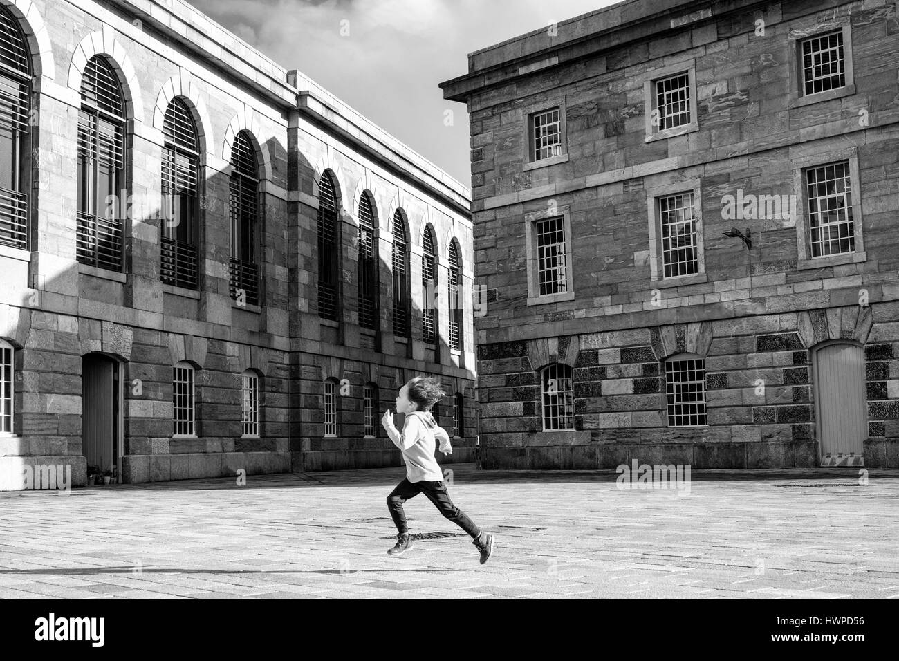 Ein kleiner Junge durch die Royal William Yard läuft, in Plymouth, Großbritannien. die Royal William Bevorratung Yard in Stonehouse, einem Vorort von Plymouth, England. Stockfoto