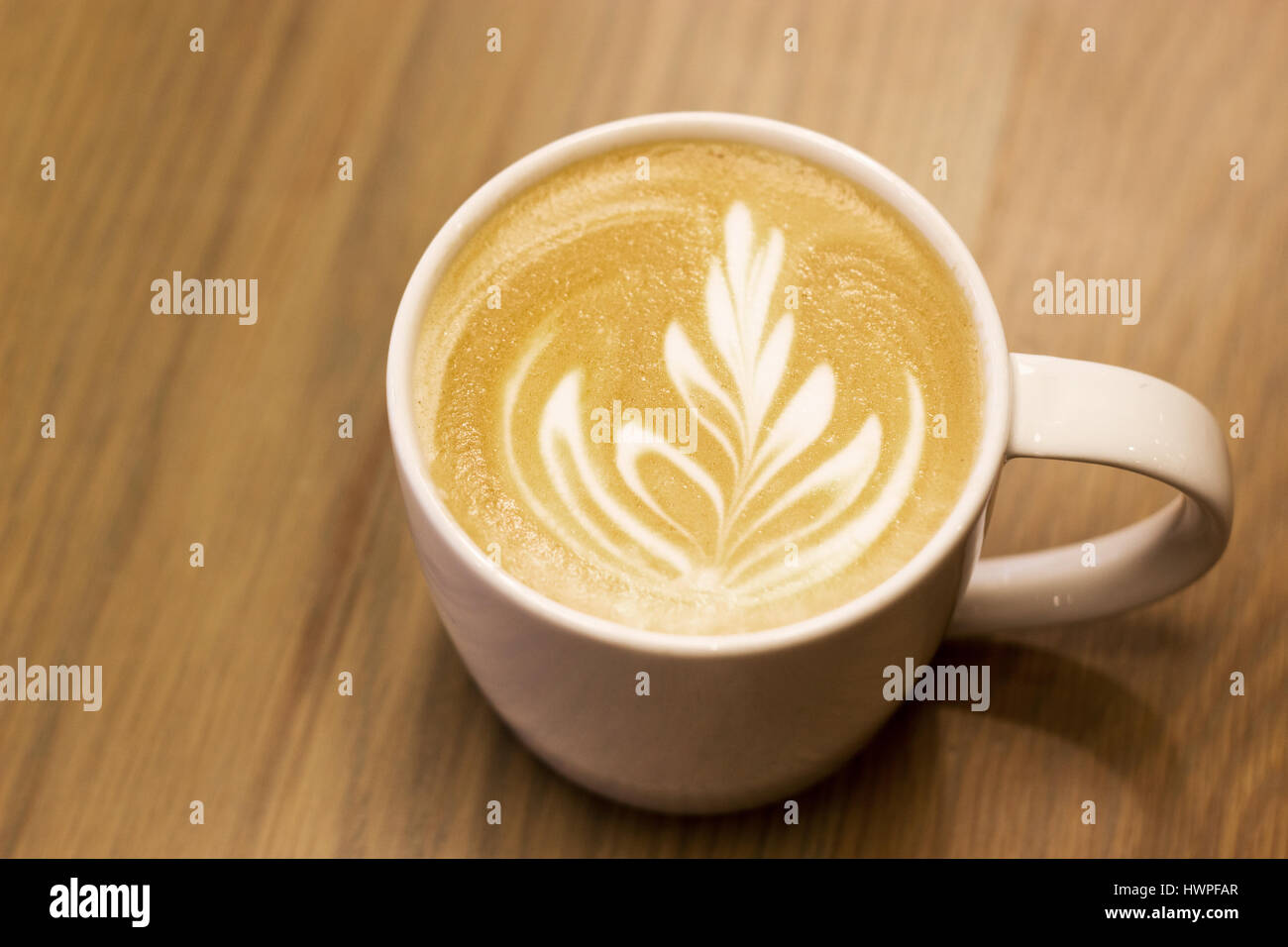 spät hautnah Kunst wie Farn auf Capucinno Kaffee auf Holz Hintergrund Stockfoto