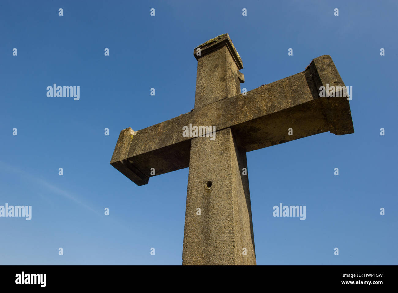 Steinkreuz vor blauem Himmel Stockfoto