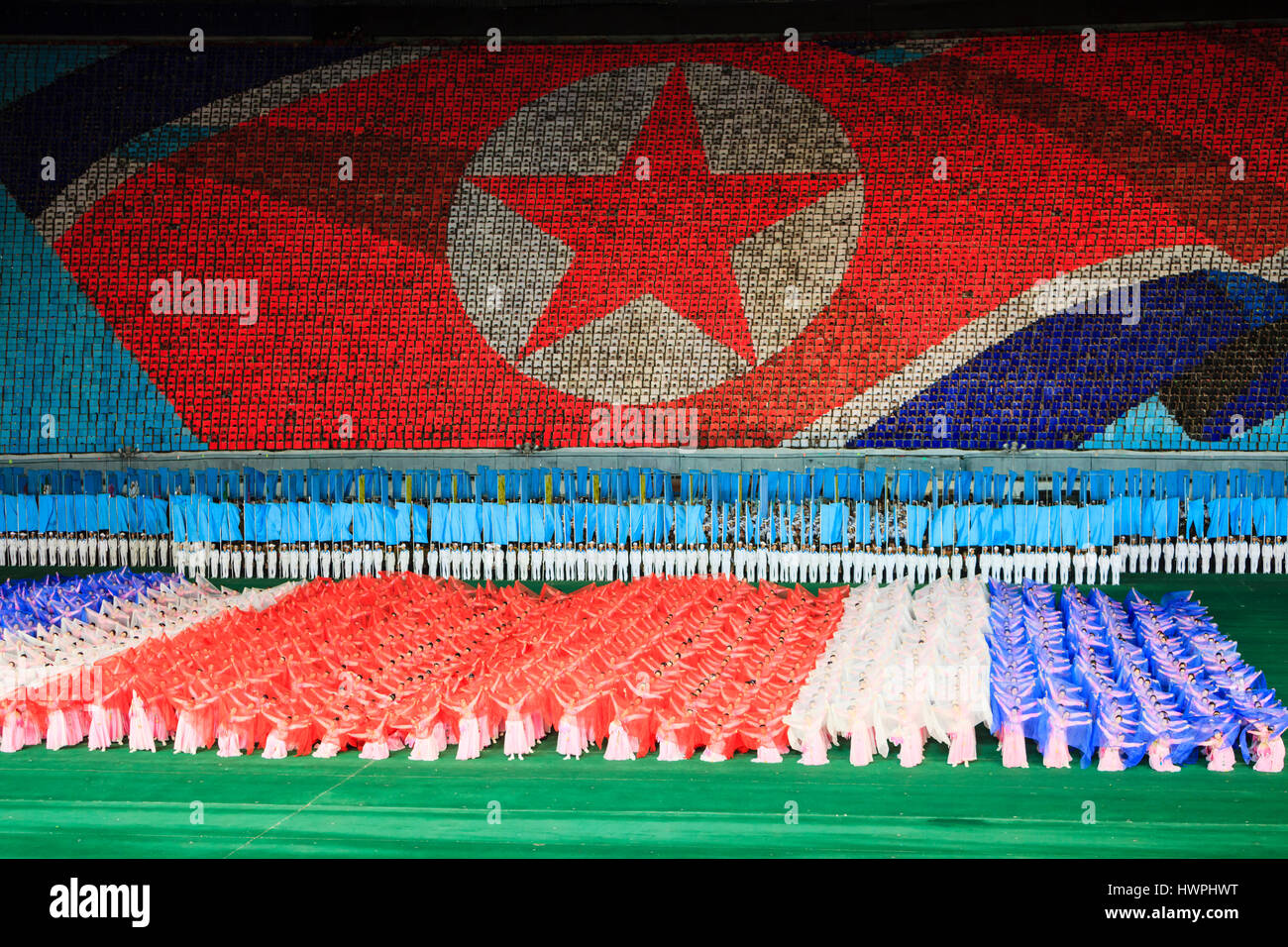 Personen im Rungnado Maifeiertag Stadium gegen nordkoreanische Flagge Stockfoto