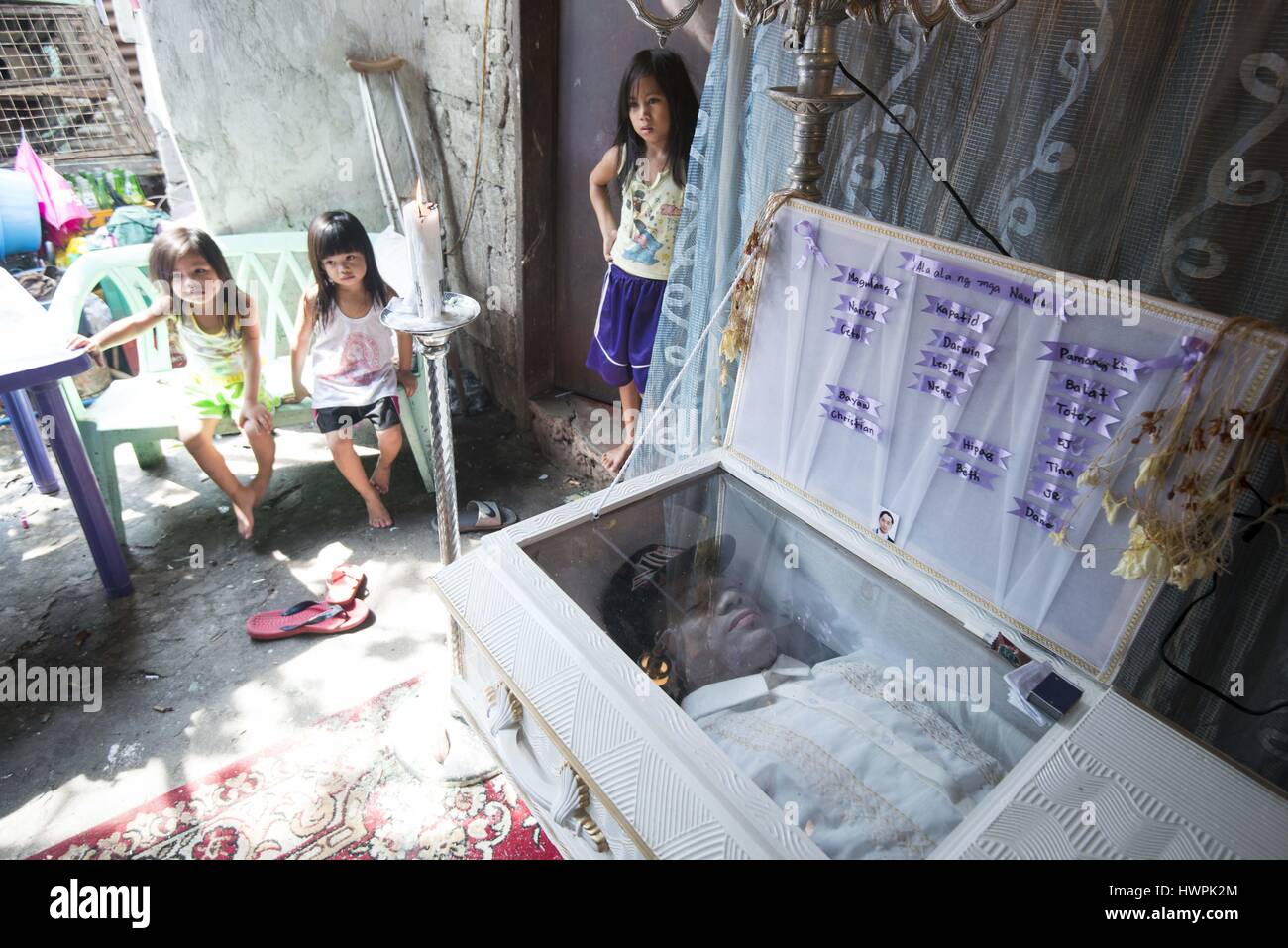 23. September 2016 - National Capital Region, Manila, Philippinen - junge Mädchen durch den Körper von Jeffry Mendoza, 31, liegt, die in einem Sarg in Matandang Balara, bei einer Totenwache für die Verstorbenen. Mendoza wurde am 23. September während einer "Buy Büste" Operation auf einer Droge-Höhle von Polizei erschossen. Polizei berichtet, dass Mendoza und sechs andere Polizei beschossen. Familie behaupten, dass die getöteten Männer unbewaffnet waren. Durch Angst in der Gemeinschaft sind Nachbarn Aufenthalt weg von sog. Mendoza Familie kämpft, um die Mittel um ihn zu begraben. Mornay Gayosa, 7, (Mitte) ist die Tochter von Almer James, 30, der war auch s Stockfoto
