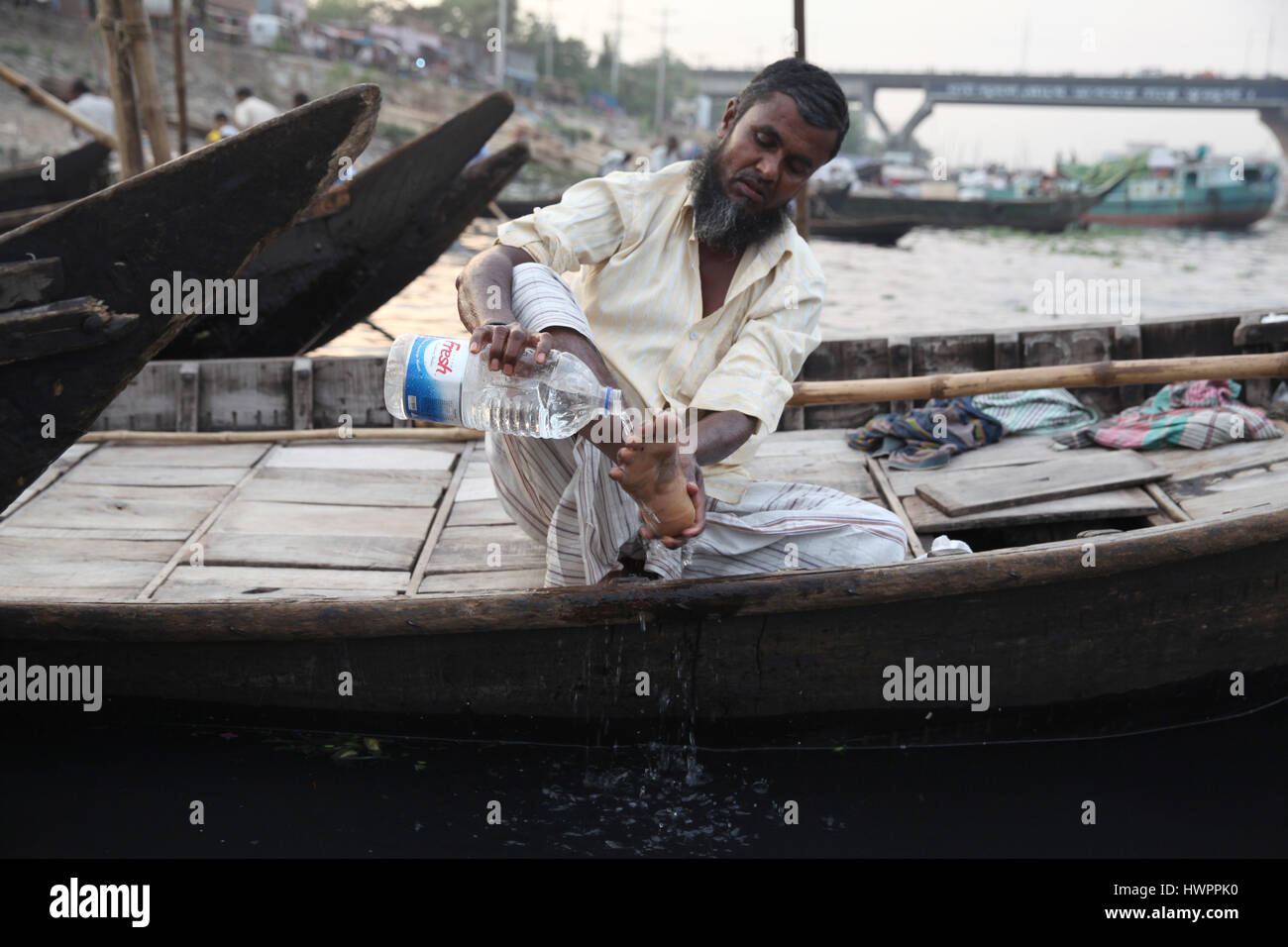 Dhaka, Bangladesch. 22. März 2017. 22. März 2017 Dhaka, Bangladesch '' "ein Bangladeshi Schiffer wäscht sein Bein um eine Schlacht von Wasser vor dem Nachmittagsgebet nimmt auf seinem Boot des Flusses Buriganga in Dhaka, Bangladesch am 22. März 2017 zu verwenden. Die Buriganga rive ist so stark verschmutzt, dass das Wasser auch nach der Behandlung ungeeignet ist. Das klebrige, pechschwarze Wasser zeigt seine hohe Verschmutzung Ebene Form Industrieabfälle. World Water Day findet jährlich am 22. März als Mittel zur Aufmerksamkeit auf die Bedeutung von Süßwasser und Eintreten für die nachhaltige Bewirtschaftung von Süßwasser Bodenschätze Stockfoto
