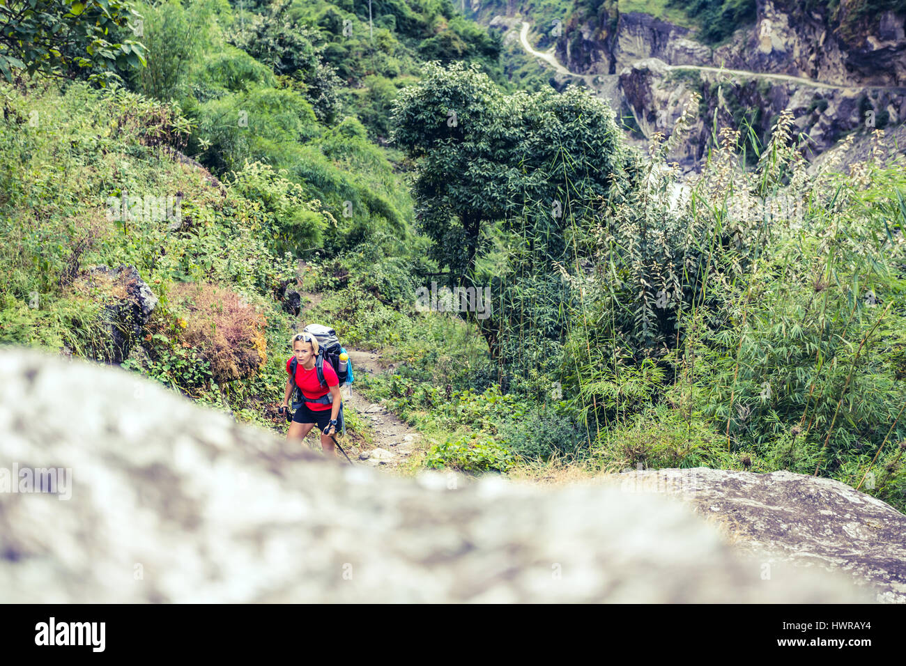 Frau Backpacker Klettern mit Rucksack im Himalaya, Nepal. Trekking und Wandern mit Rucksack im Hochgebirge. Annapurna Himal Range auf Annapurna C Stockfoto